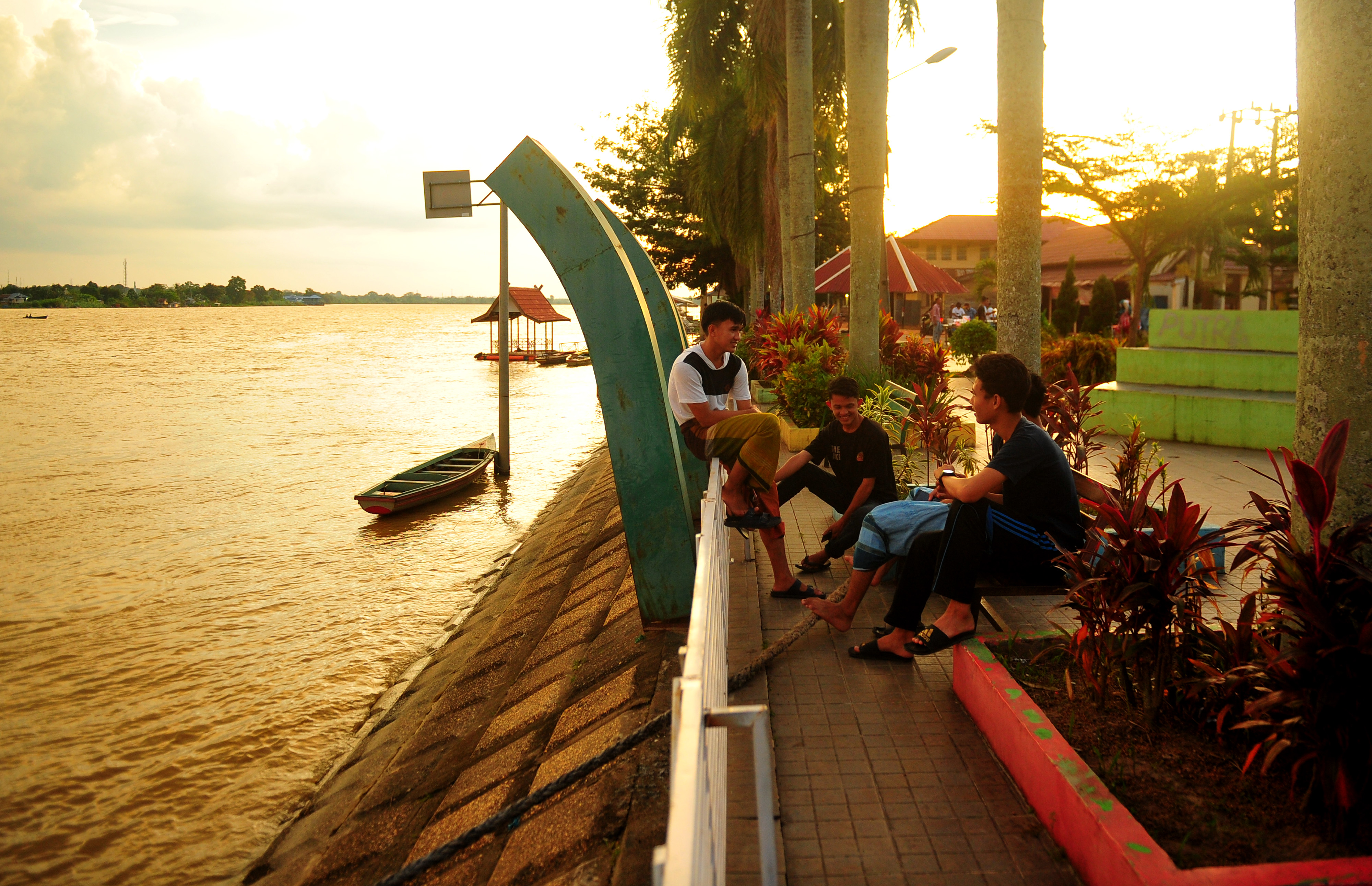 Warga menunggu waktu berbuka puasa (ngabuburit) di taman kota, tepi Sungai Batanghari, Pelayangan, Jambi, Jumat (24/4).