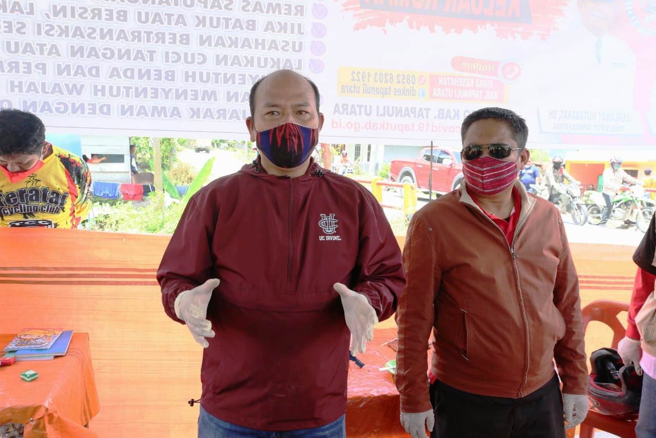 Bupati Nikson Nababan (kiri), Sekda Indra Sahat Simaremare (kanan) mengenakan alat pelindung diri.