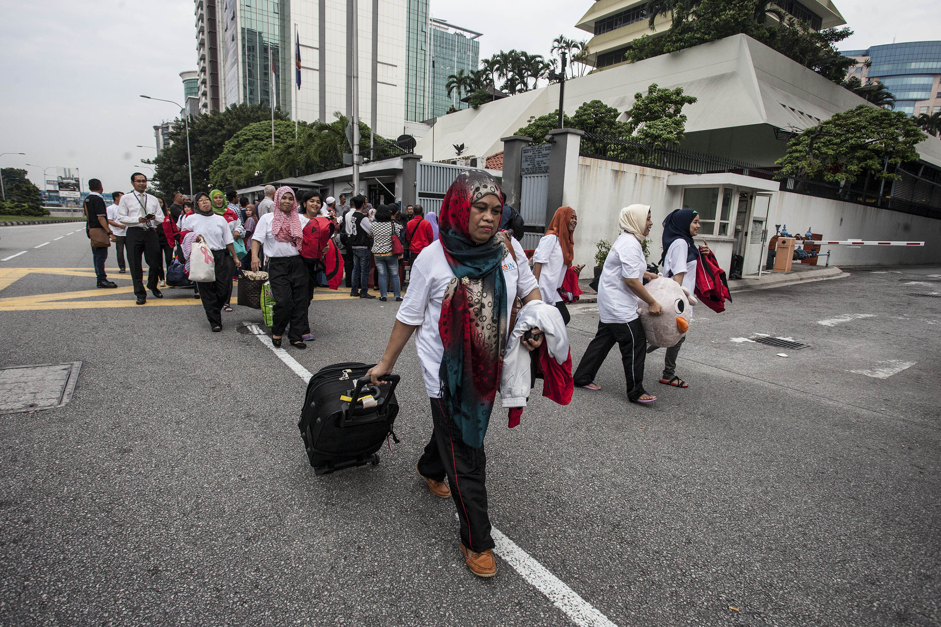 Sejumlah Buruh Migran Indonesia (BMI) berjalan menuju bandara untuk pulang ke Indonesia di kantor Kedutaan Besar Indonesia di Kuala Lumpur. 