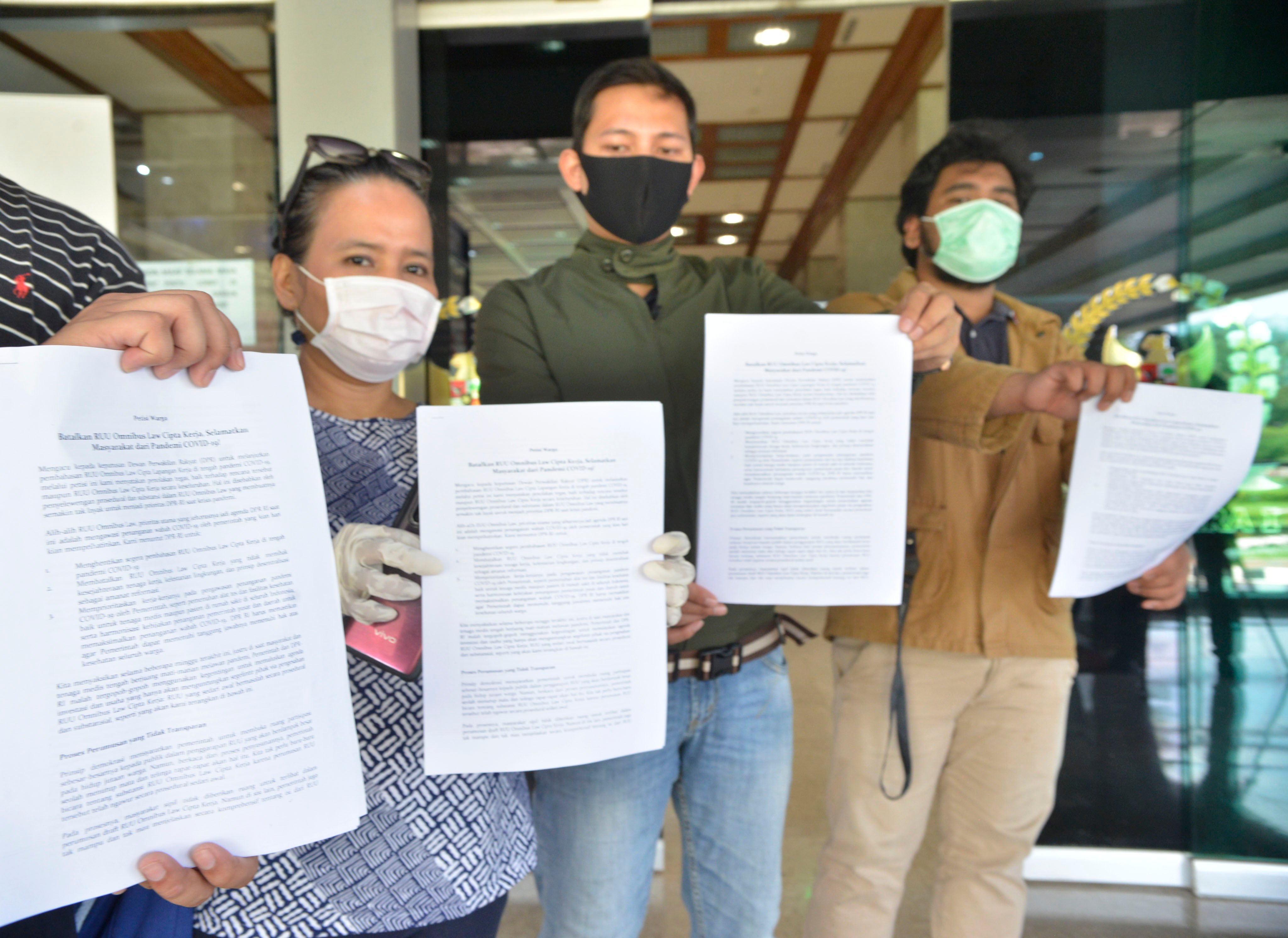 Perwakilan LSM, Organisasi dan Masyarakat yang tergabung dalam Petisi Warga menunjuka isi petisi untuk disampaikan ke Badan Legislasi DPR.