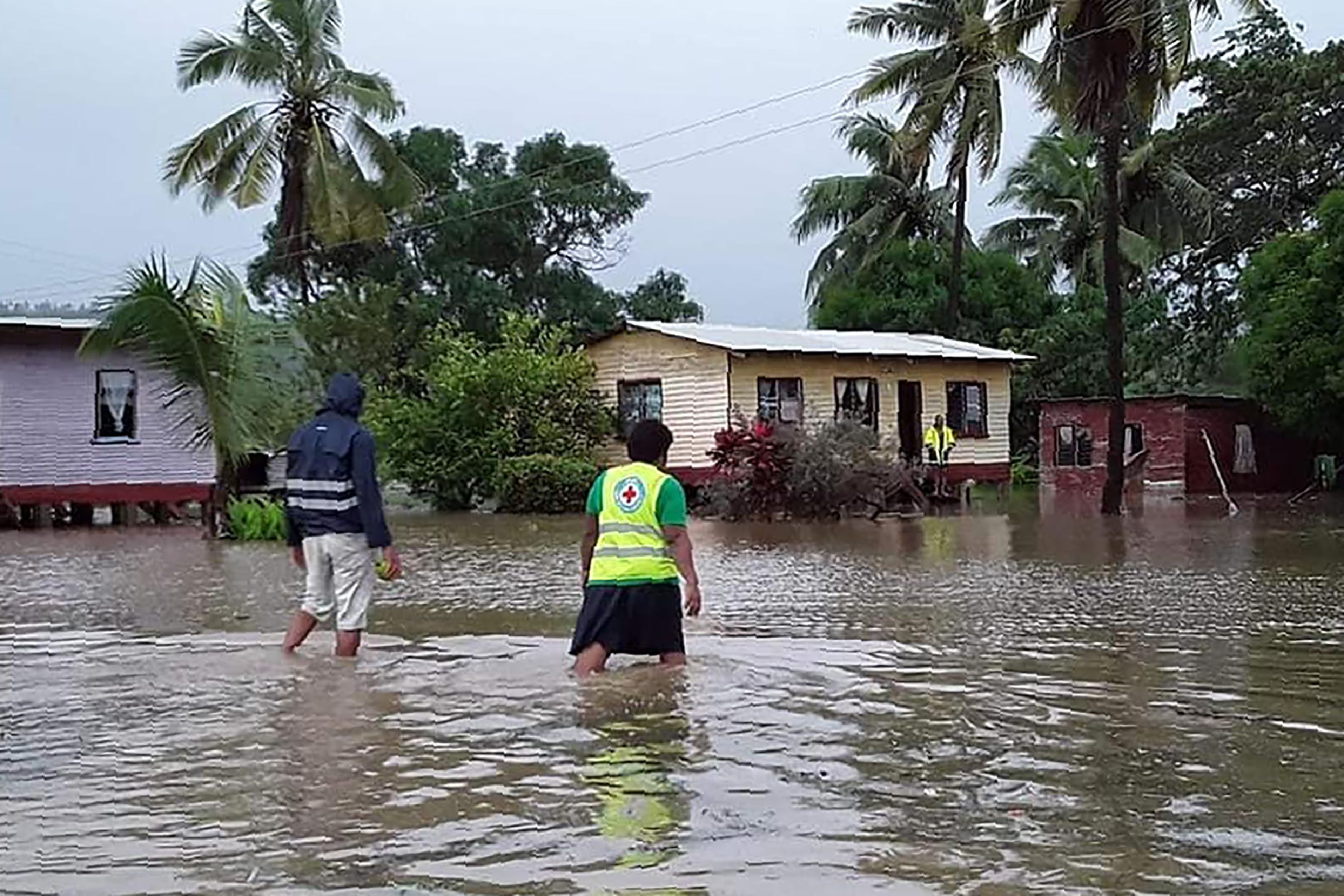 Warga di Kepulauan Fiji melintasi banjir yang disebabkan terjangan Topan Harold.