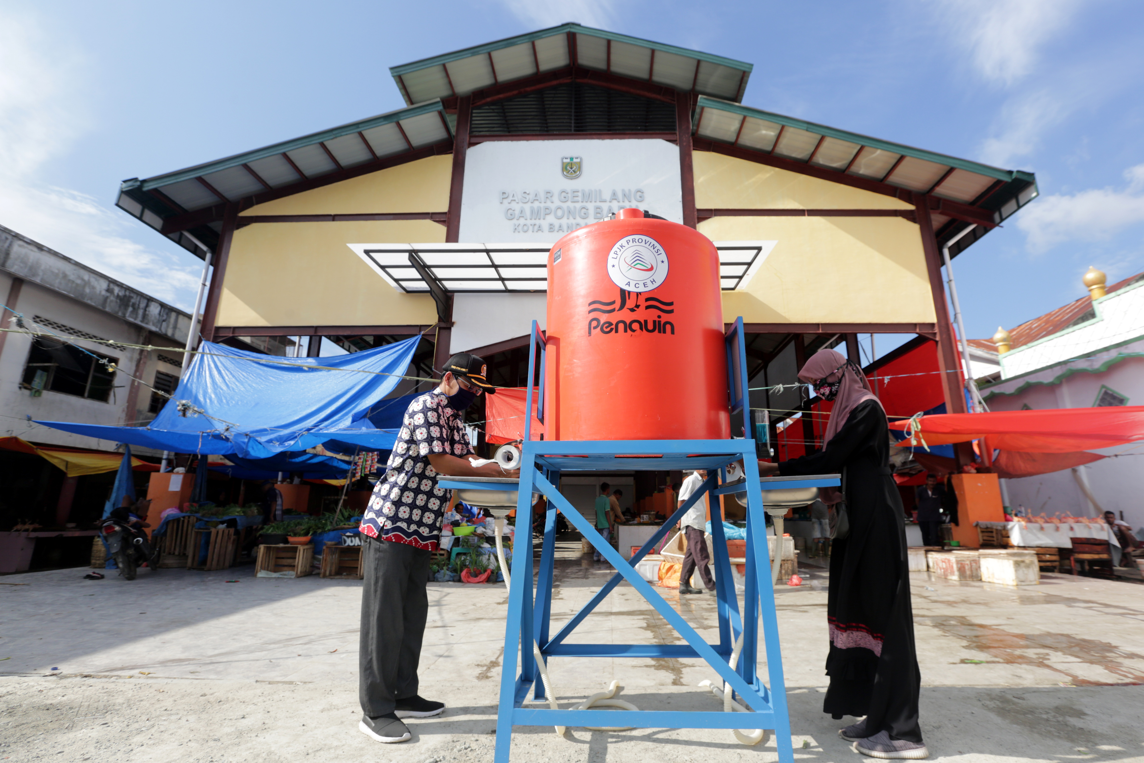 Ketua DPRK Banda Aceh Farid Nyak Umar (kiri) mencuci tangan di wastafel portabel bantuan UKM Pencinta Alam Leuser, Sabtu (11/4/2020).