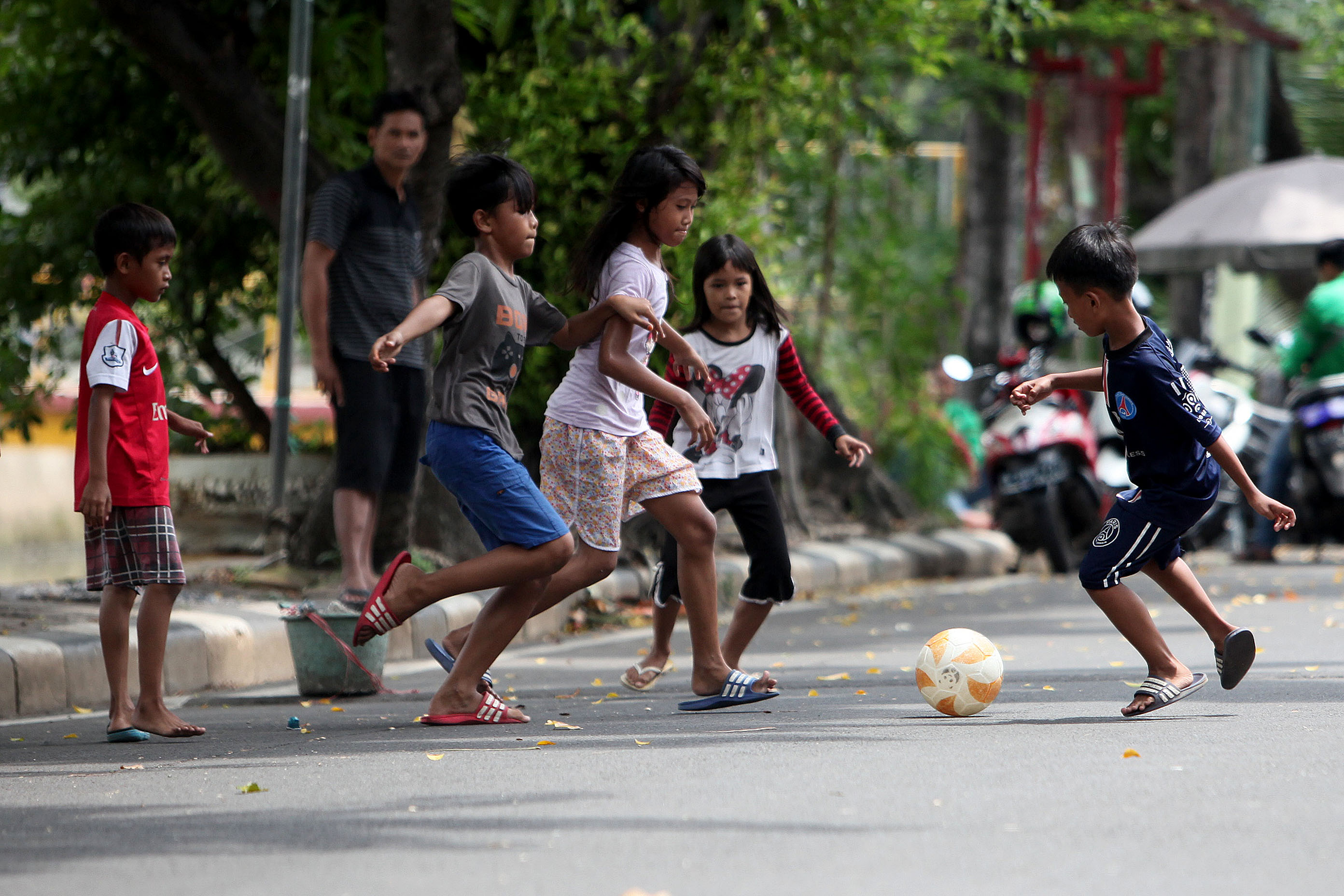 Anak-anak bermain sepak bola di jalanan di kawasan Pasar Baru, Jakarta, Rabu (25/03)