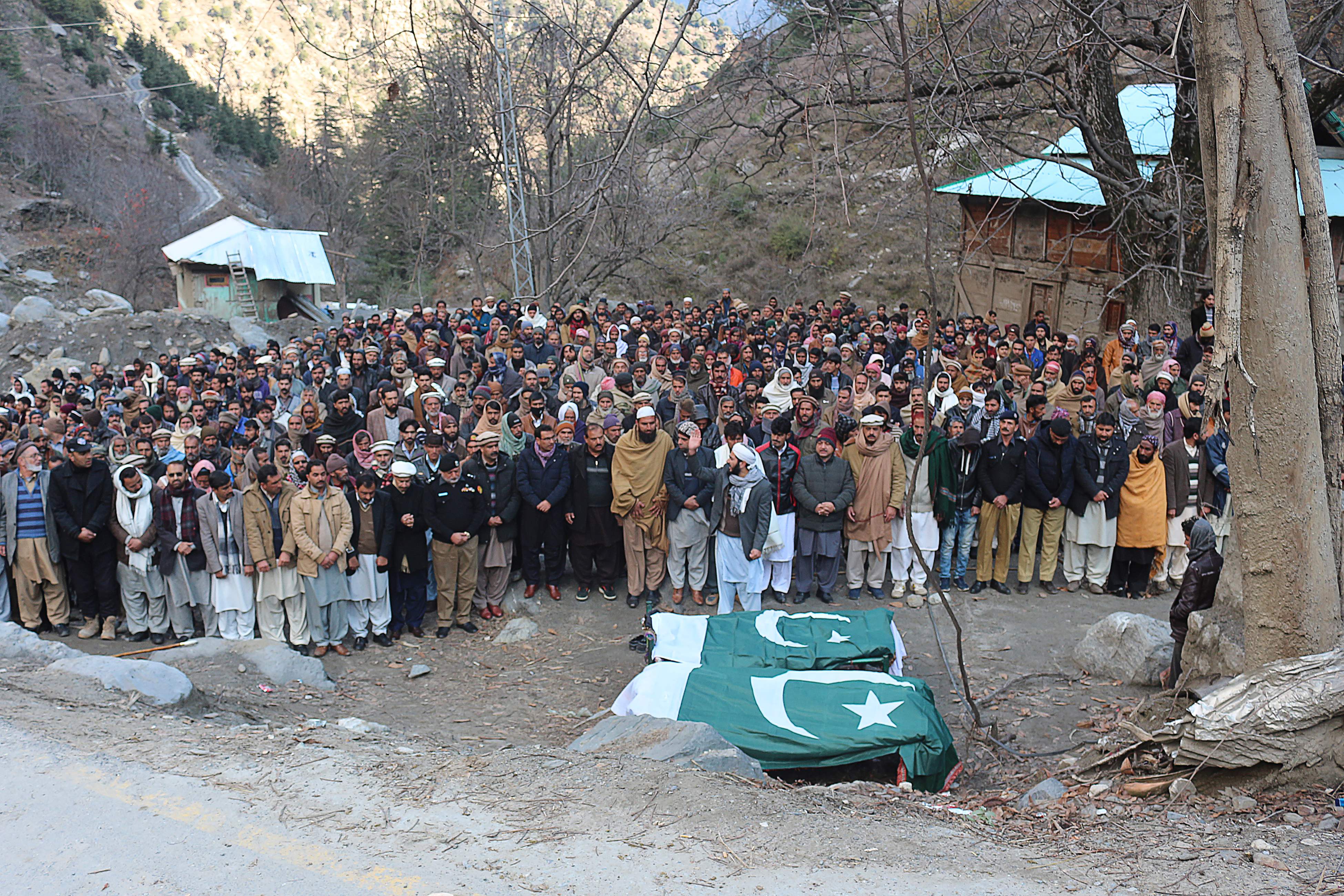 Orang-orang menggelar salat jenazah di sebelah tubuh para korban penembakan di Lembah Laswa, dekat perbatasan Kashmir, Pakistan. 