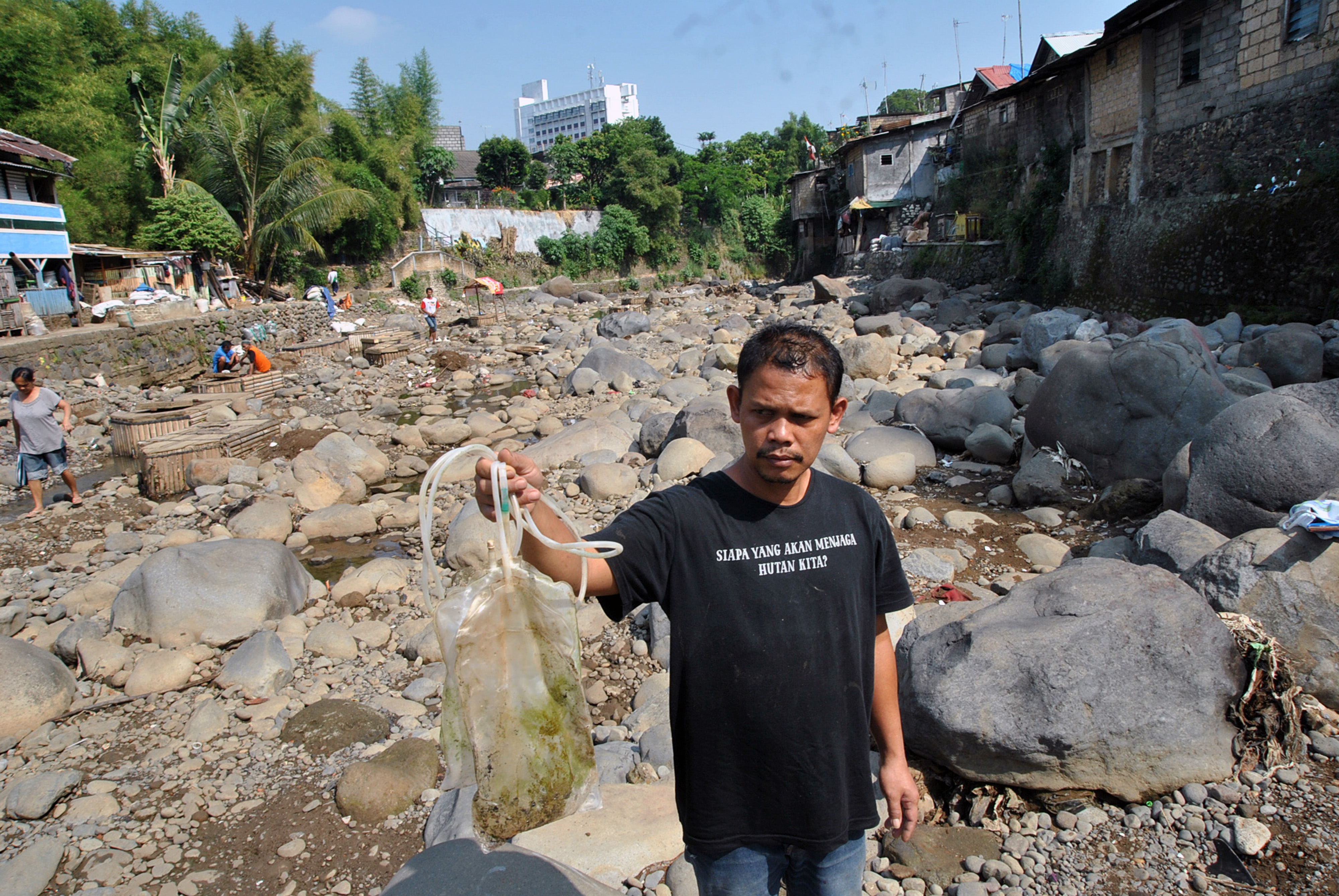 Penggiat lingkungan dari Komunitas Peduli Ciliwung menunjukkan limbah medis di sungai Ciliwung, Kampung Kebon Jukut, Bogor