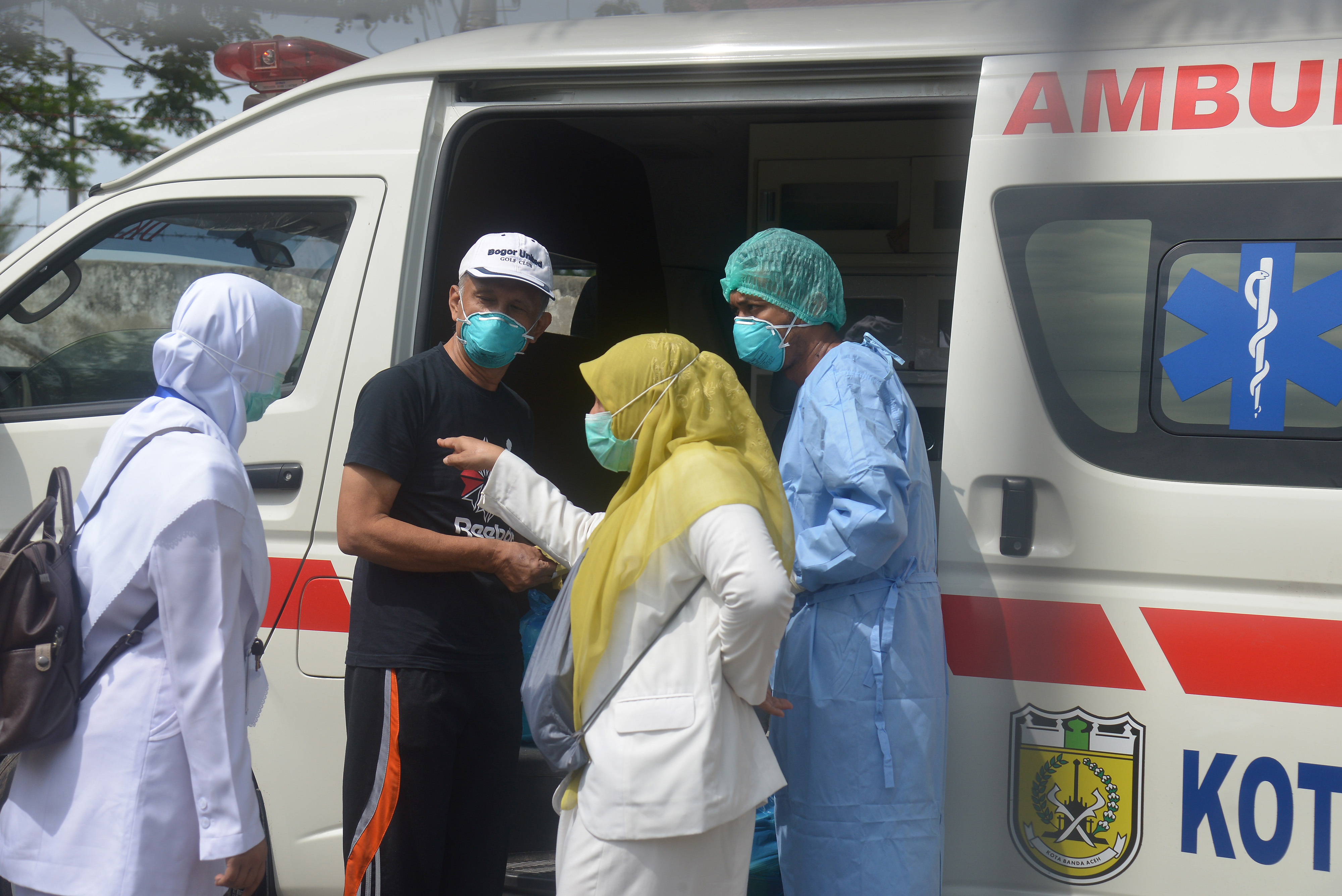 Seorang pasien positif COVID-19 (kedua kiri) yang sembuh bersiap menaiki ambulans saat pemulangan di RS Zainal Abidin BAnda Aceh13/4)