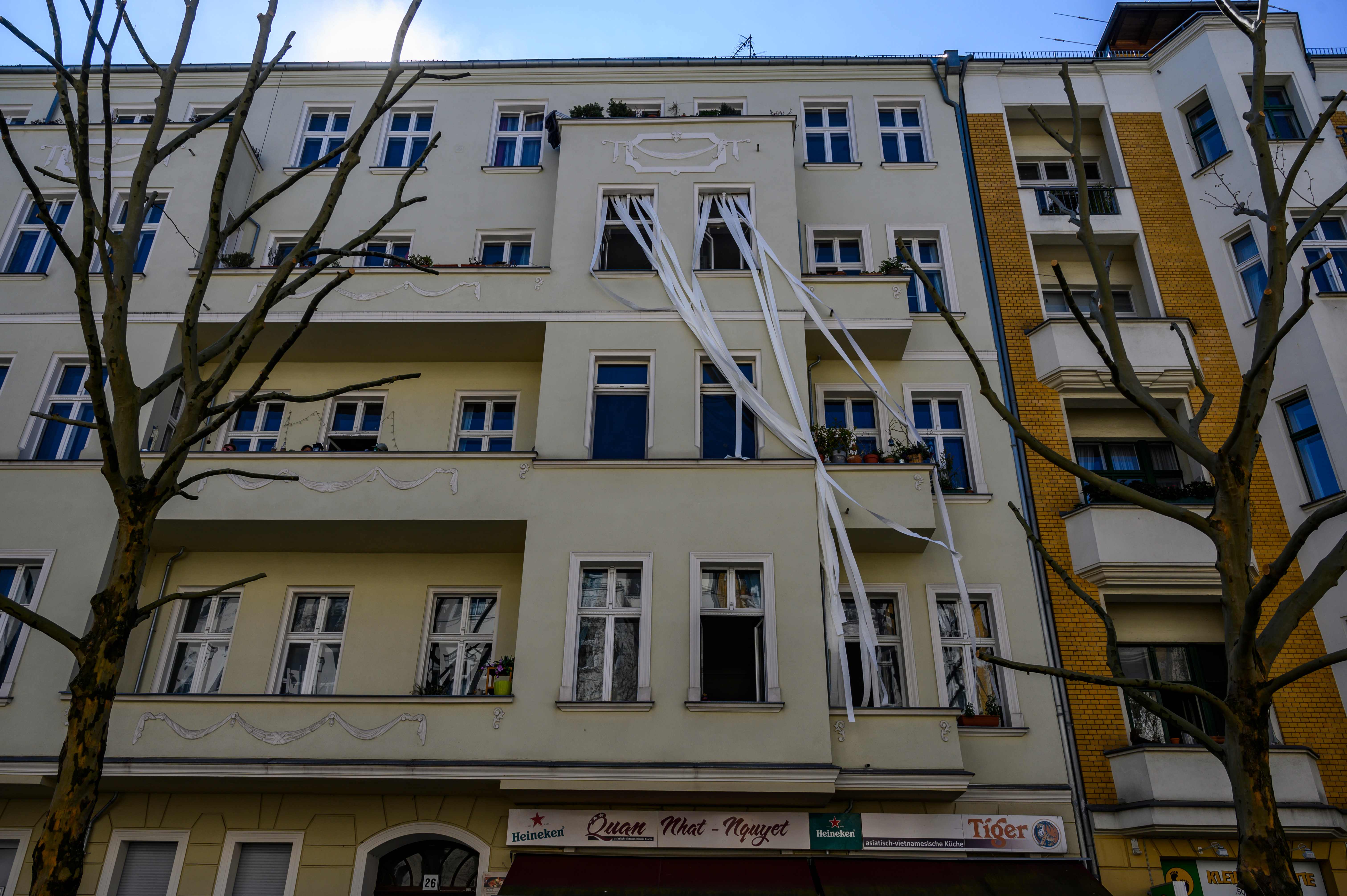 Sebuah instalasi menyajikan pita kertas toilet yang memjulur ke bawah di bagian depan gedung apartemen di Berlin.