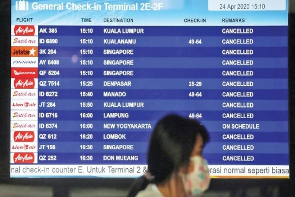Calon penumpang melintas di depan papan elektronik jadwal penerbangan di Terminal 2 Bandara Soekarno-Hatta, Tangerang, Banten, kemarin.