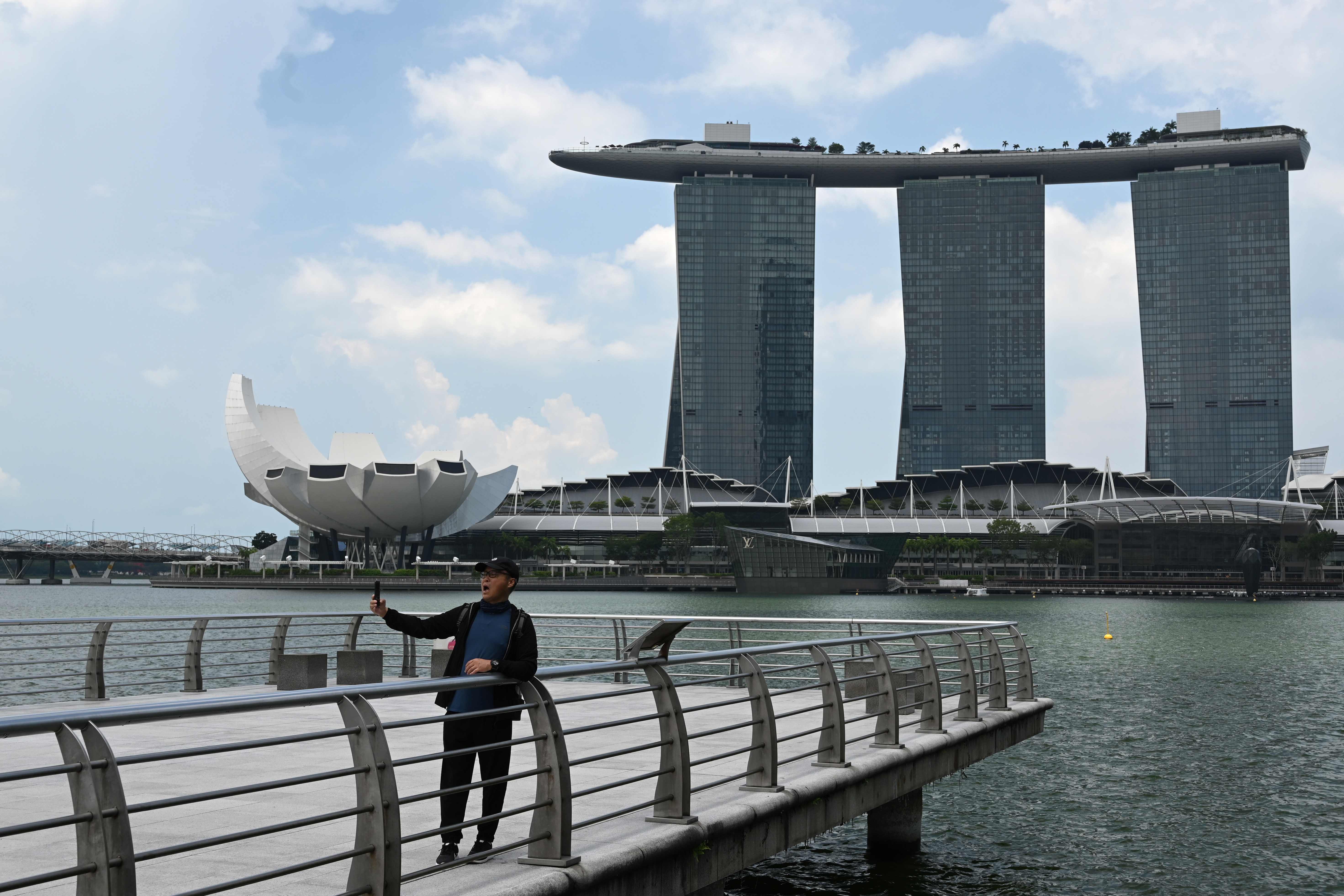 Seorang pria sedang berswafoto dengan latar belakang Marina Bay Sands resort di Marina Bay Singapura pada 2 April 2020