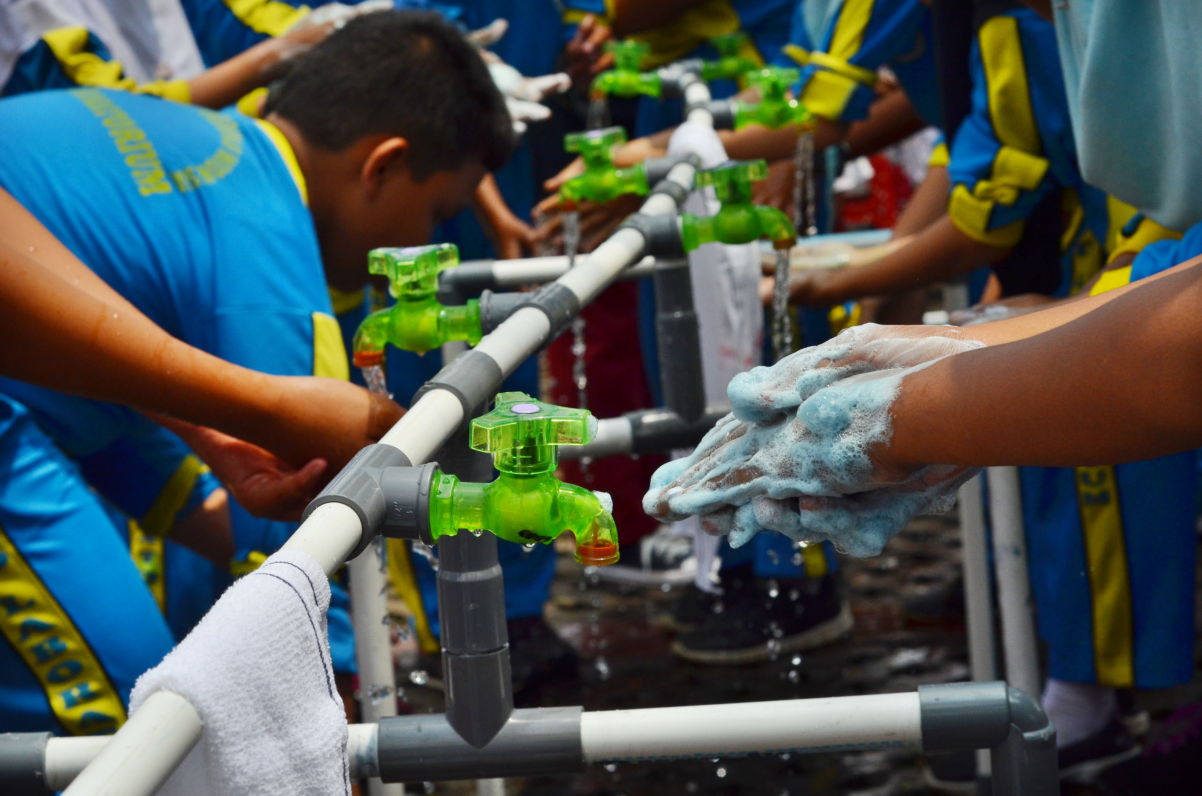 Anak-anak mencuci tangan dengan sabun. Mencuci tangan dengan sabun antiseptik bisa memutus penularan virus.