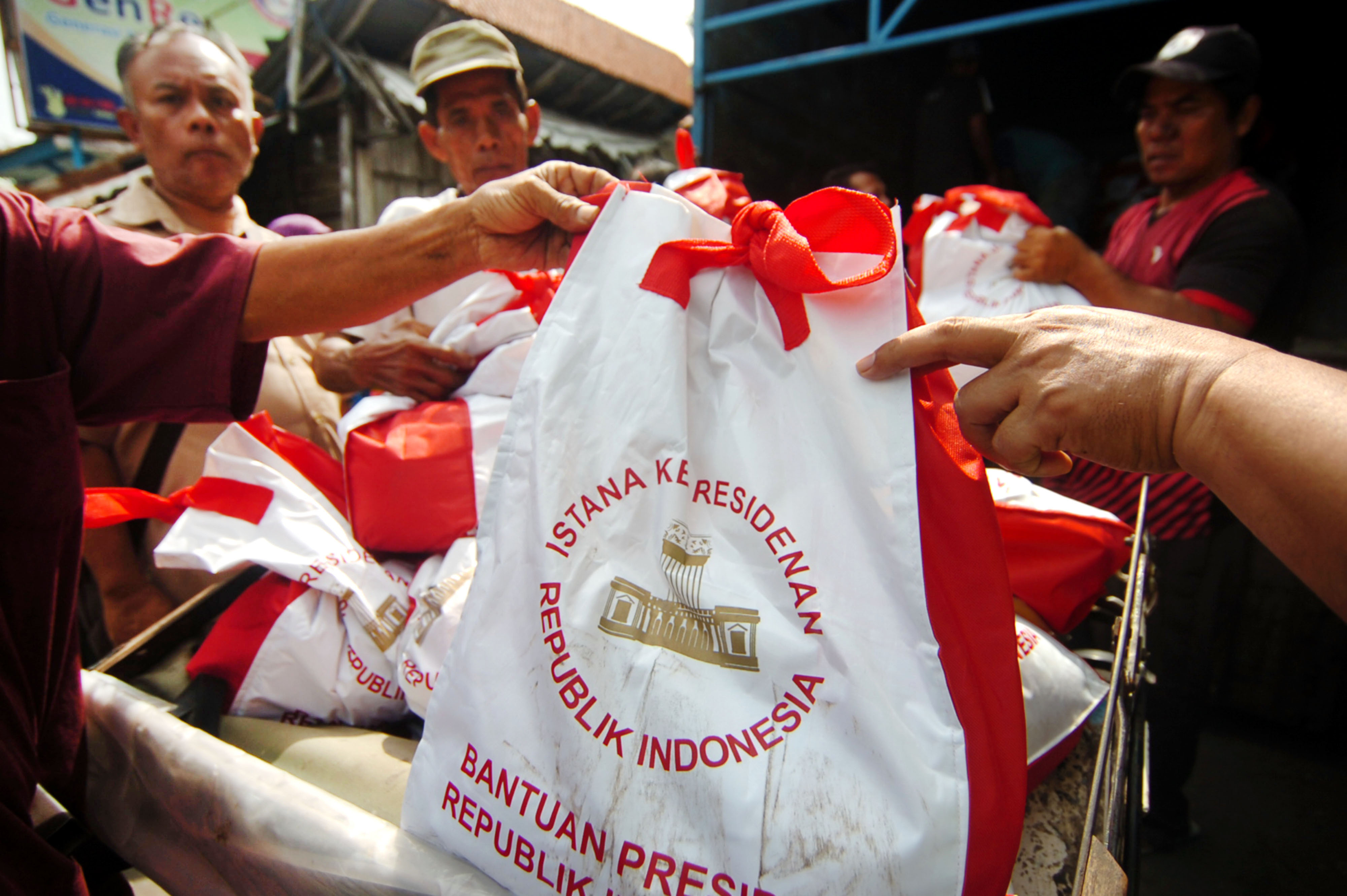  Sejumlah warga menerima pembagian sembako bantuan Presiden Joko Widodo di Pasar Trayeman, Kabupaten Tegal