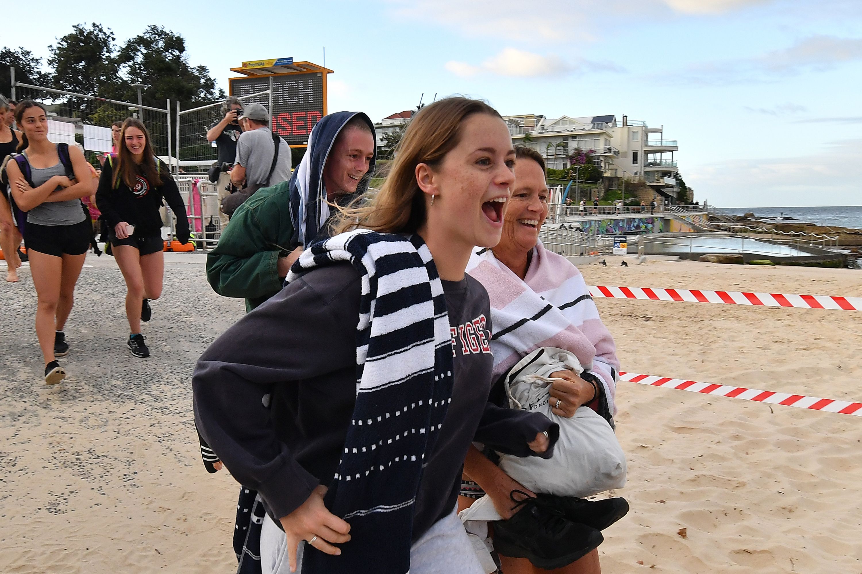 Beachgoers berlari menuju Pantai Bondi yang baru dibuka lagi setelah tutup selama 5 minggu (28/4)