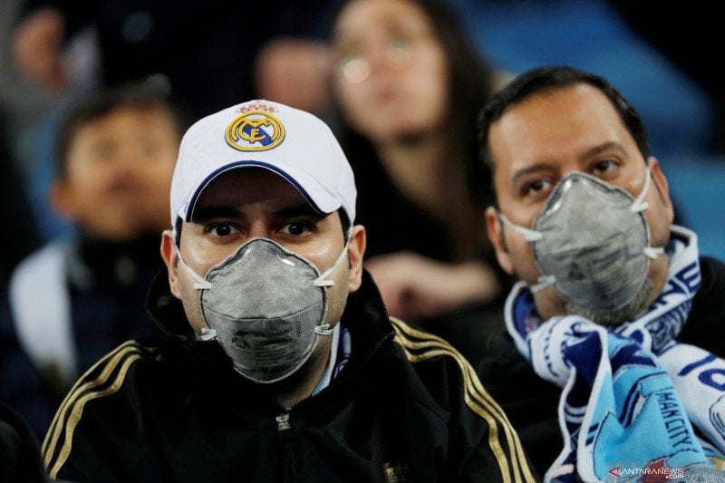 Pendukung Real Madrid menggunakan masker di tengah kekhawatiran penularan virus korona di dalam stadion.