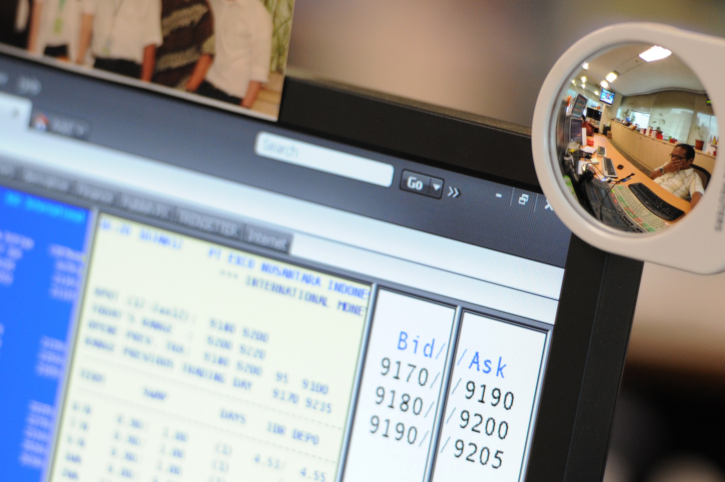 Refleksi karyawan yang memantau pergerakan pasar uang dan obligasi.