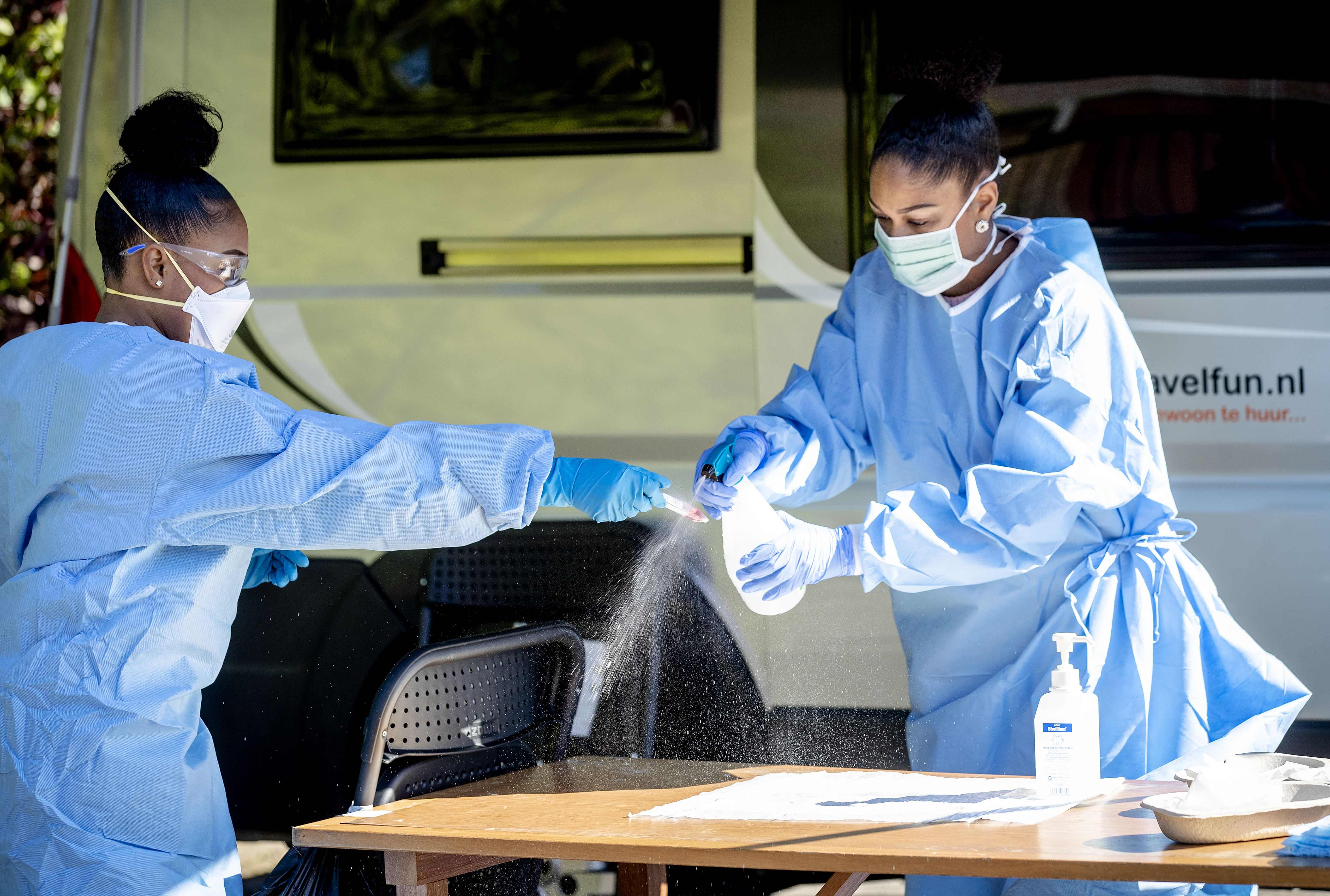 Petugas menyemprotkan disinfektan ke alat rapid test covid-19 di Middelharnis, Belanda.