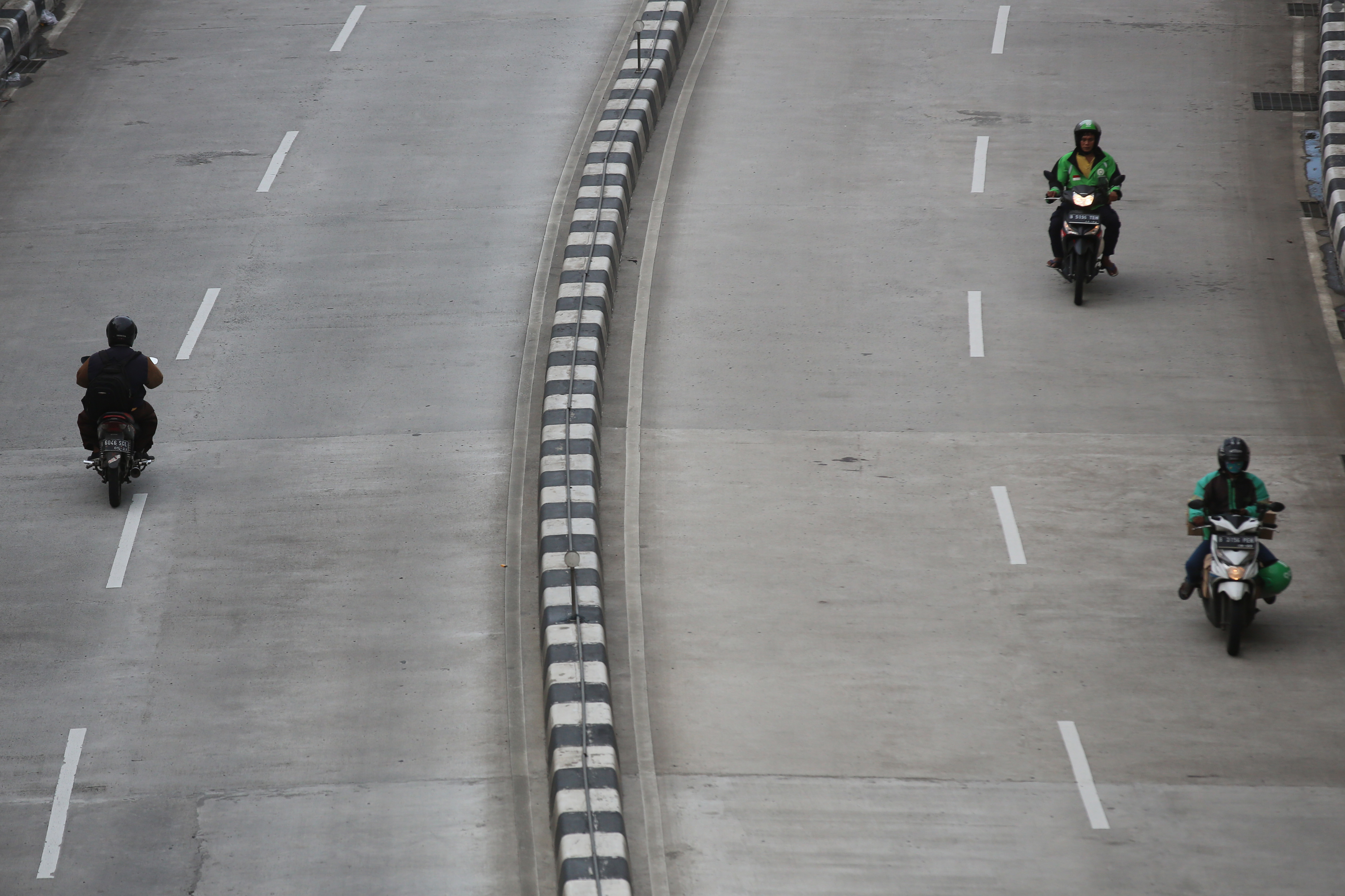 engendara ojek dalam jaringan atau daring melintas di kawasan Mampang, Jakarta yang kosong karena wabah covid-19.