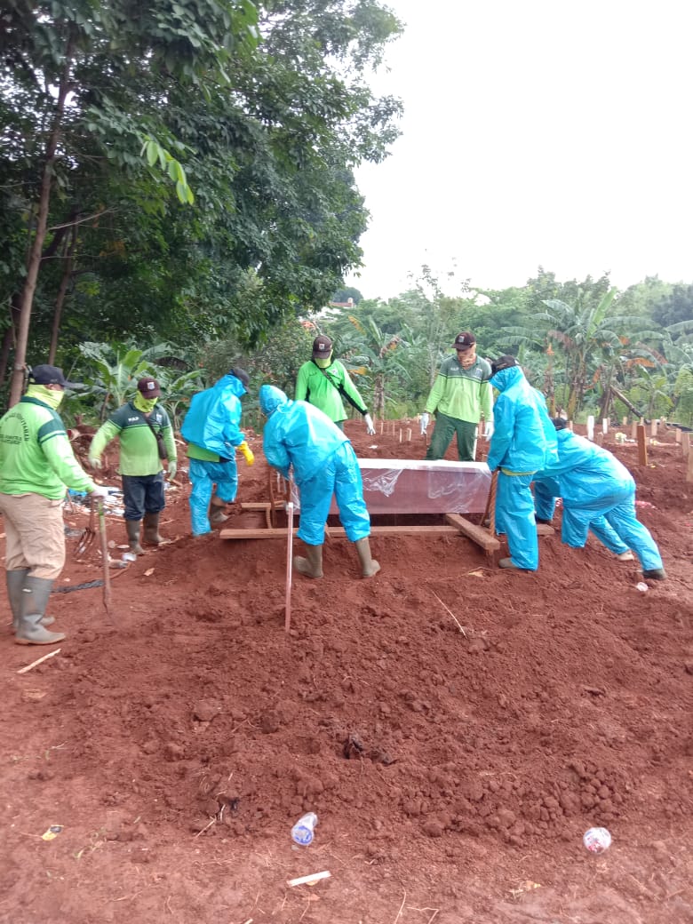 Petugas pemakaman TPU Pondok Ranggon memakamkan jenazah sesuai SOP penanganan Covid-19