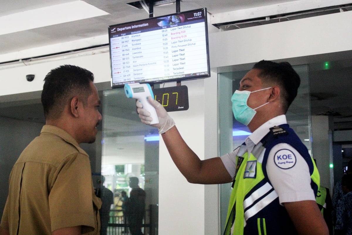 Petugas memeriksa suhu tubuh calon penumpang di Bandara El Tari Kupang, Nusa Tenggara Timu (NTT).