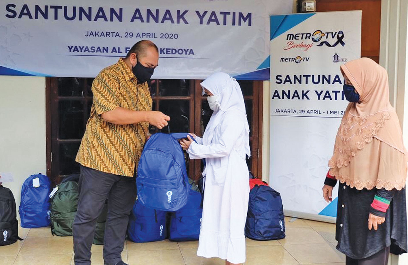 Managing Director Metro TV Mohammad Mirdal Akib (kiri) menyerahkan bantuan kepada perwakilan anak yatim di Yayasan Al Fitroh Kedoya,  