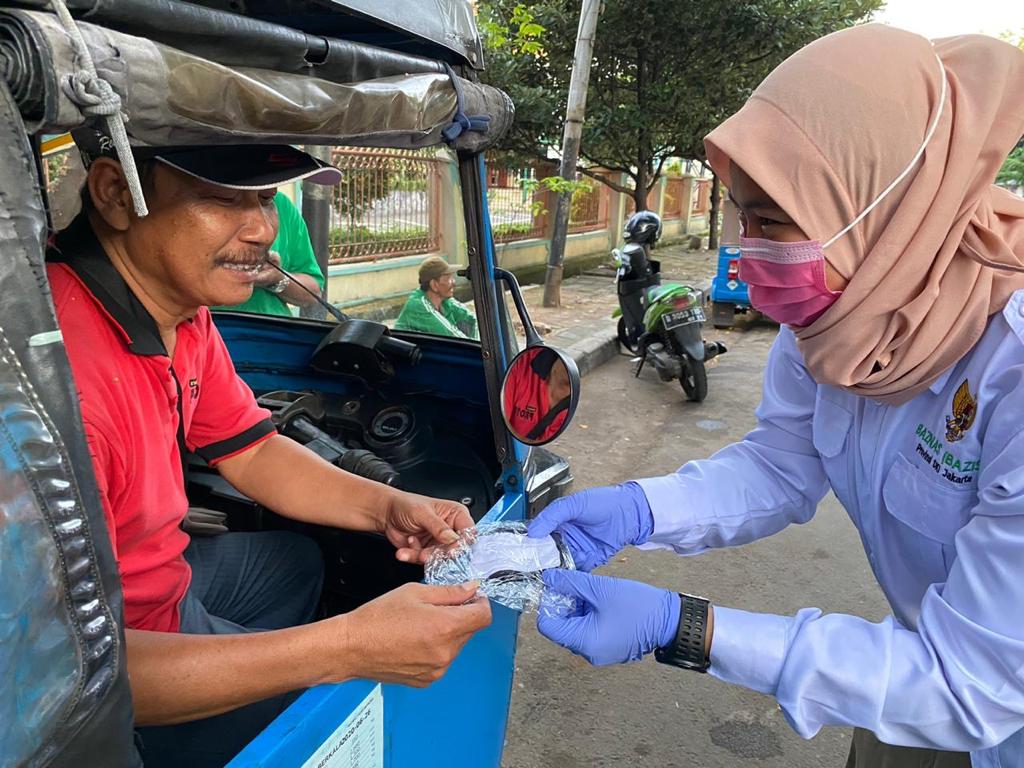 Pembagian masker gratis kepada warga yang masih harus mencari nafkah di luar di wilayah DKI Jakarta.  