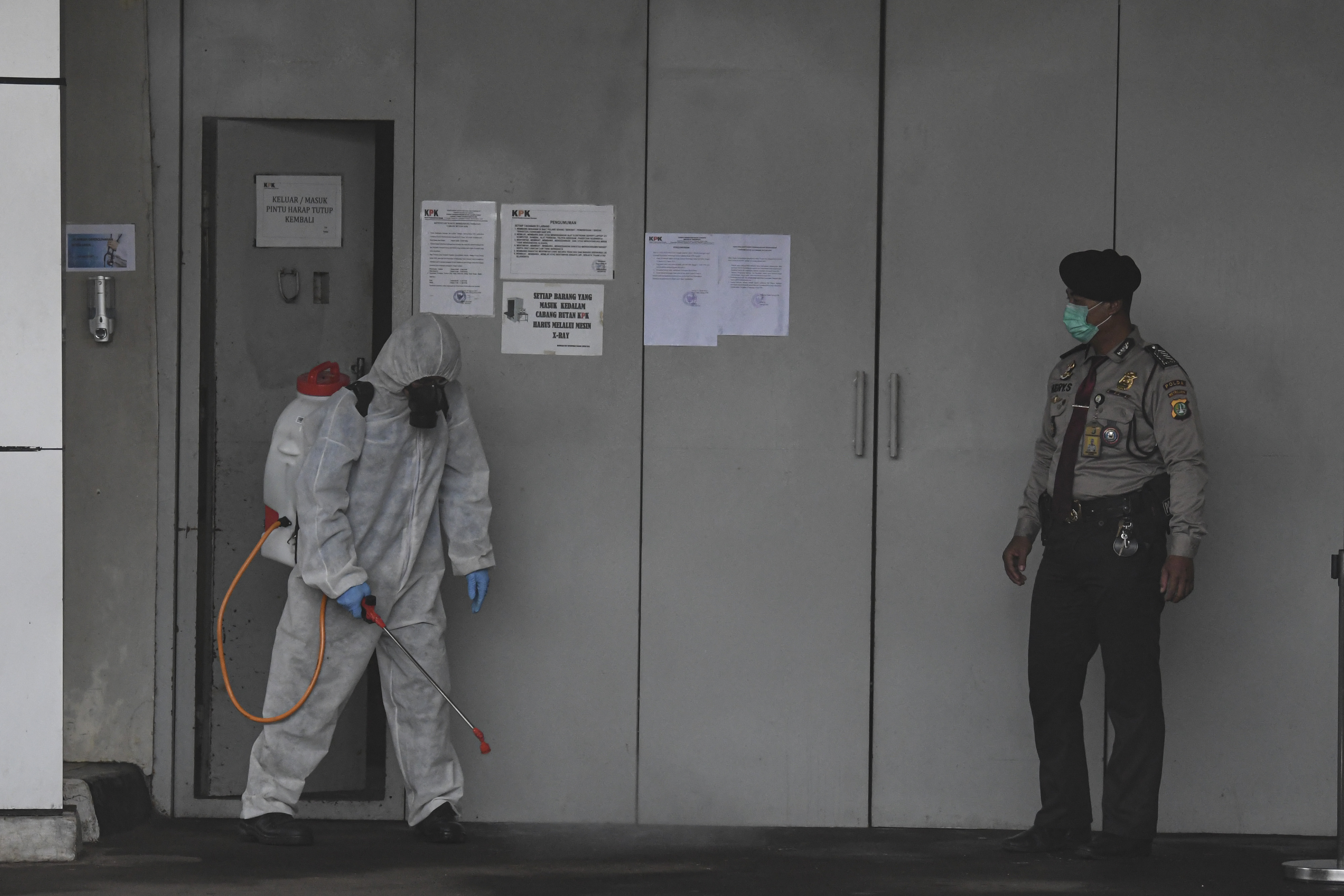 Petugas menyemprotkan cairan disinfektan di pintu masuk rumah tahanan KPK di Jakarta, Rabu (18/3). 