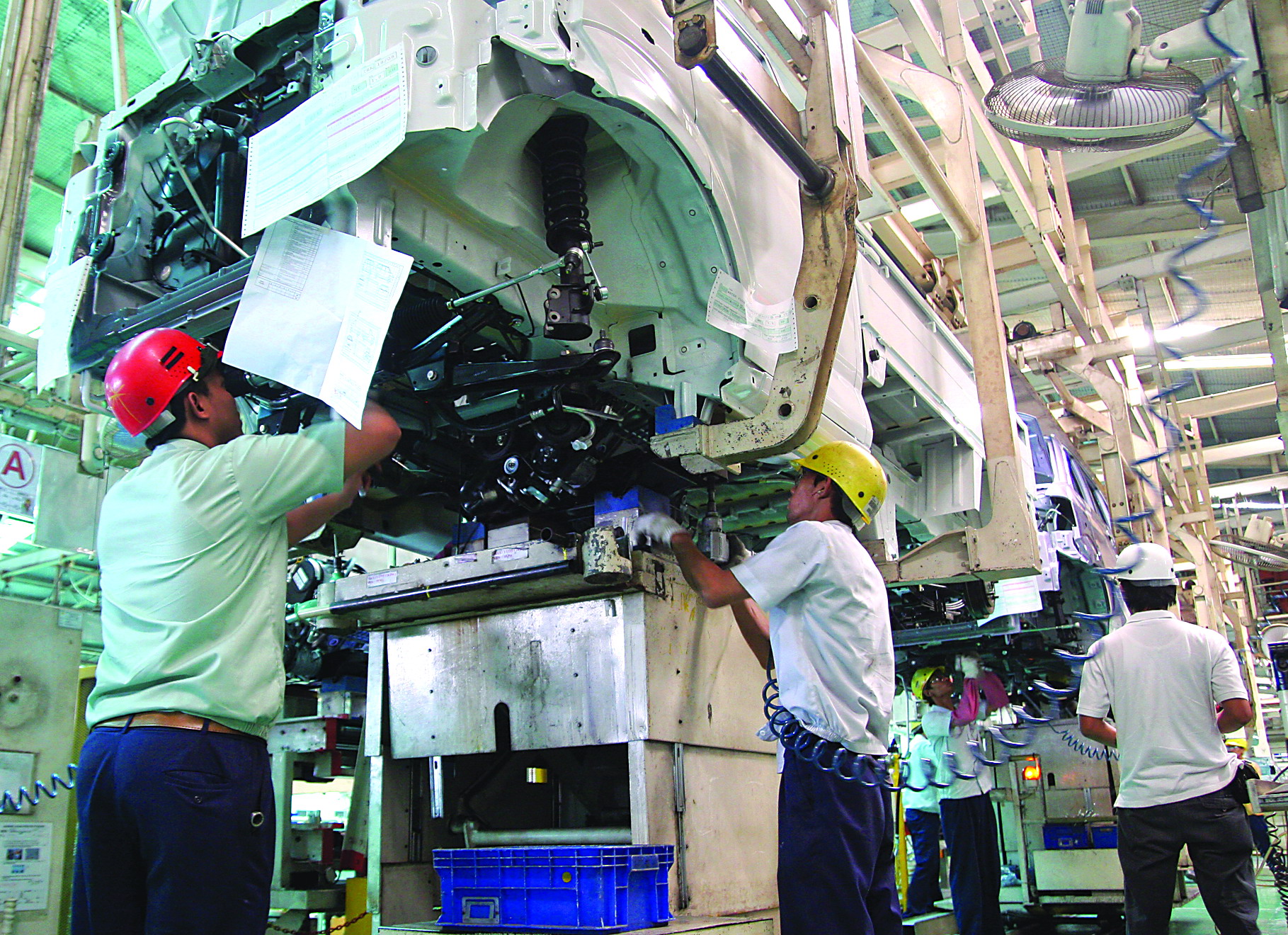 Pekerja sedang merakit mobil di pabrik Suzuki.