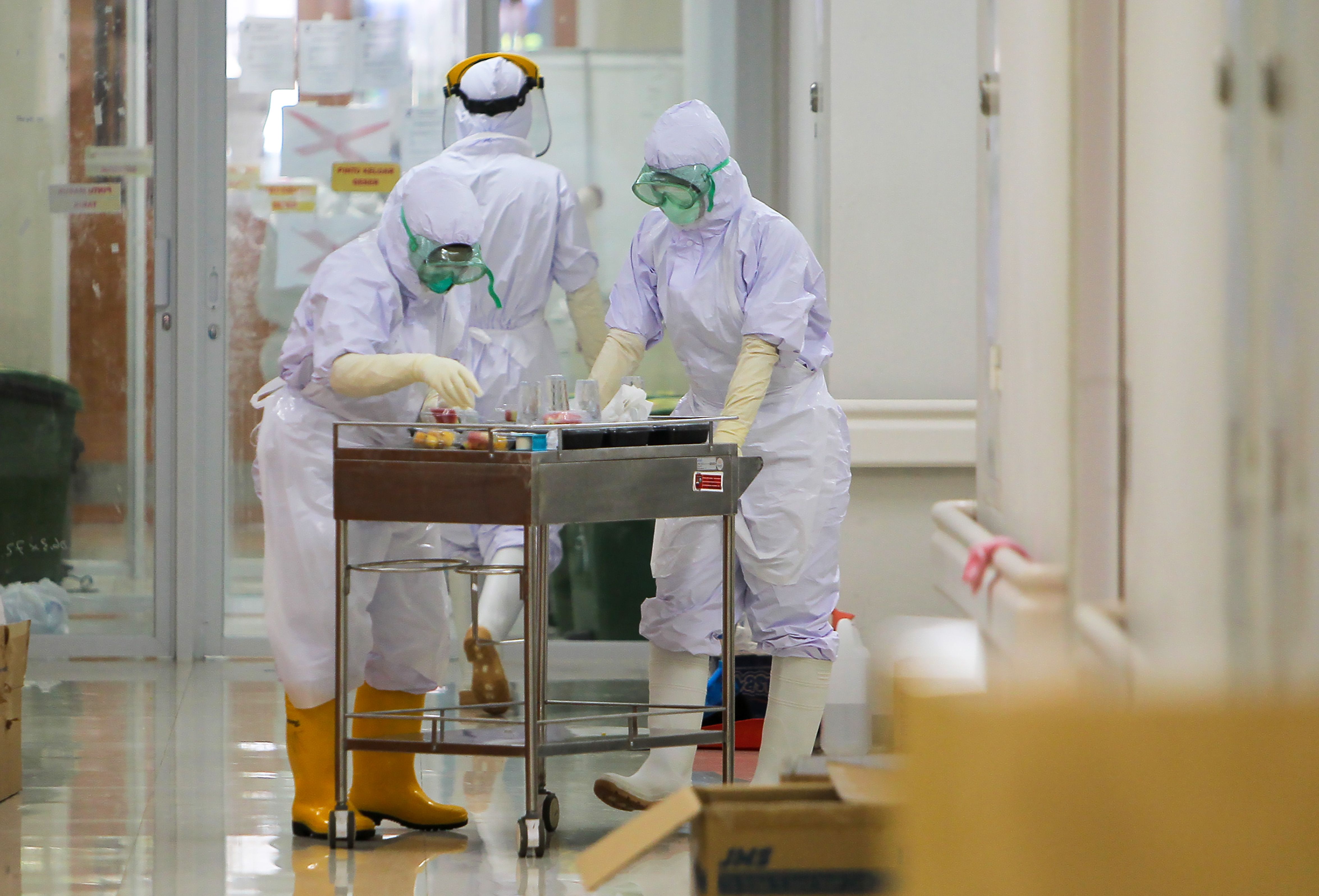 Pekerja dapur rumah sakit dengan APD lengkap memberikan makanan pasien covid-19 di bagian isolasi rumah sakit umum Bogor.