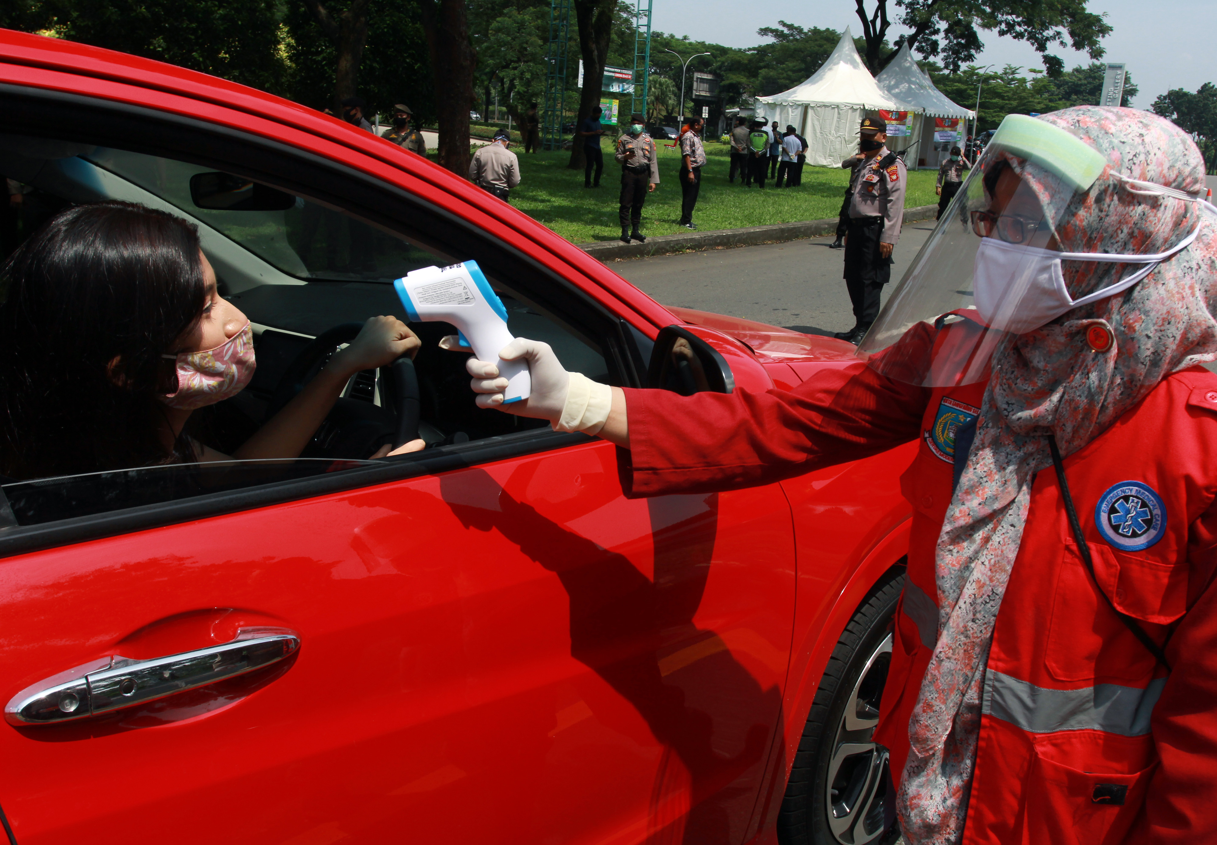 Petugas dari Dinas Kesehatan Tangsel melakukan pemeriksaan suhu tubuh pengendara dan penumpang mobil yang memasuki wilayah Tangerang Selatan