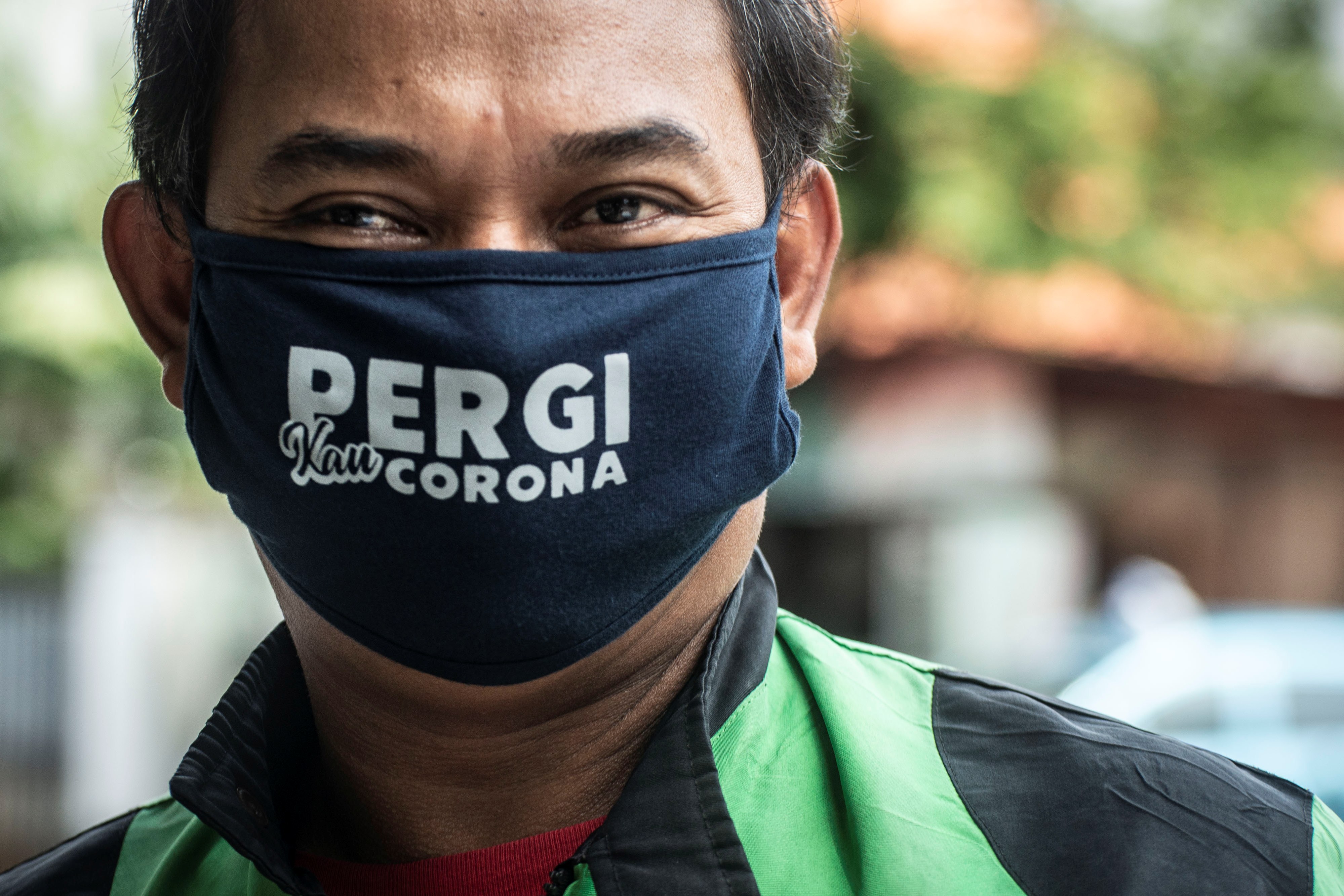 Pengemudi ojek daring menggunakan masker.