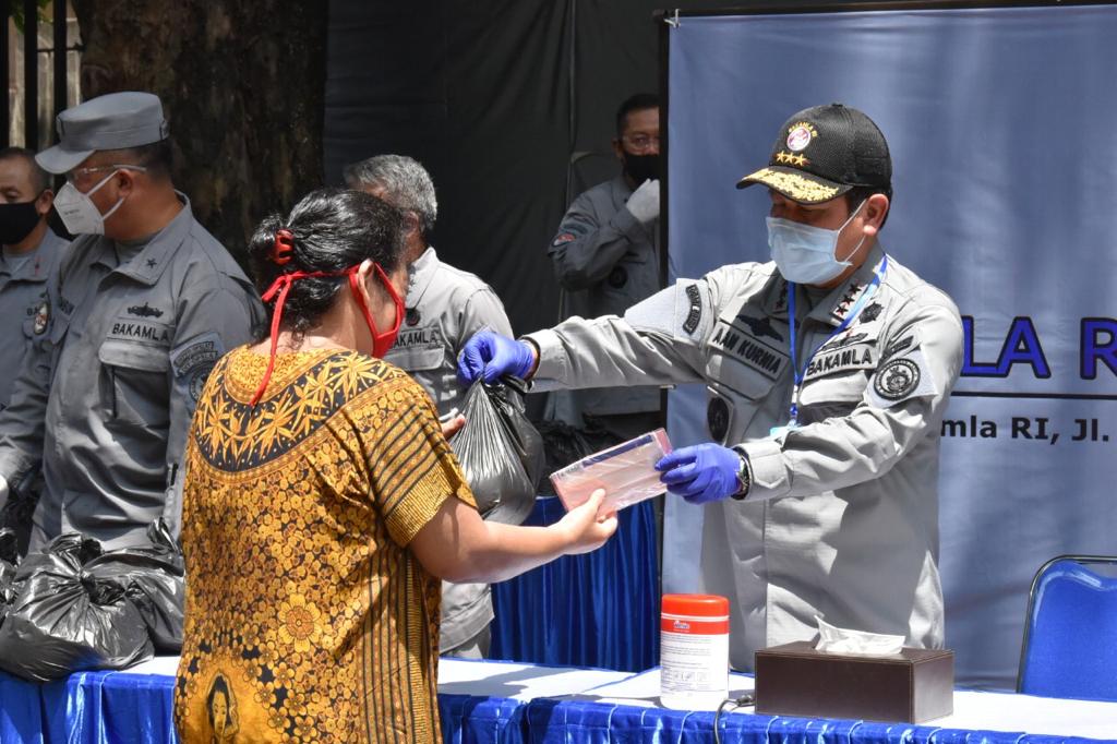 Petugas Bakamla memberikan bantuan bagi warga terdampak covid-19