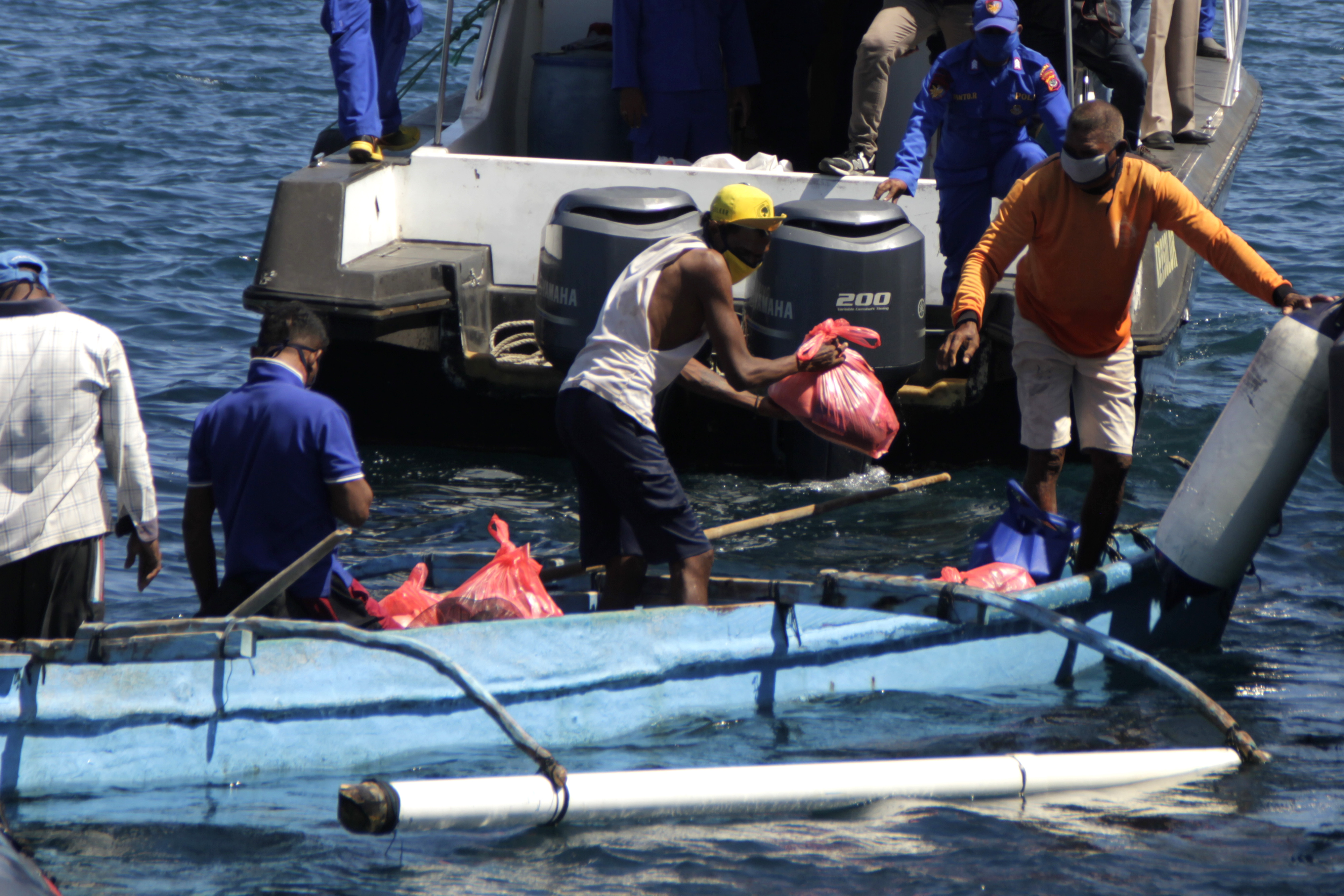 Nelayan mendapatkan sembako dari Polda Nusa Tenggara Timur di perairan Kupang, NTT, Rabu (15/4). 