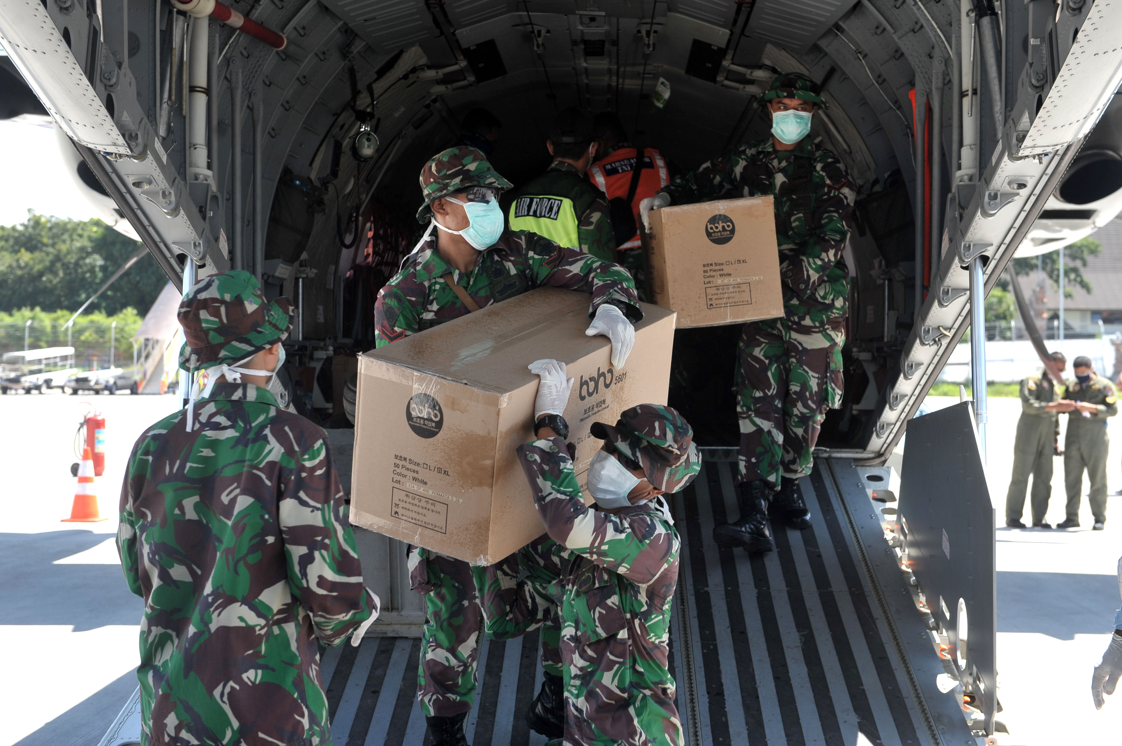 Prajurit TNI AU memindahkan alat kesehatan dari pesawat CN-295 yang tiba di Bandara I Gusti Ngurah Rai, Bali.