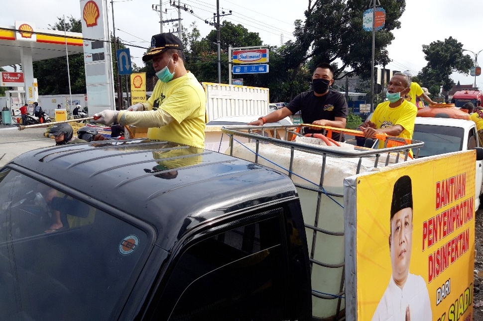 Anggota DPRD Jawa Timur Siadi (kiri) melakukan penyemprotan disinfektan di Kecamatan Lawang, Kabupaten Malang, Sabtu (18/4).