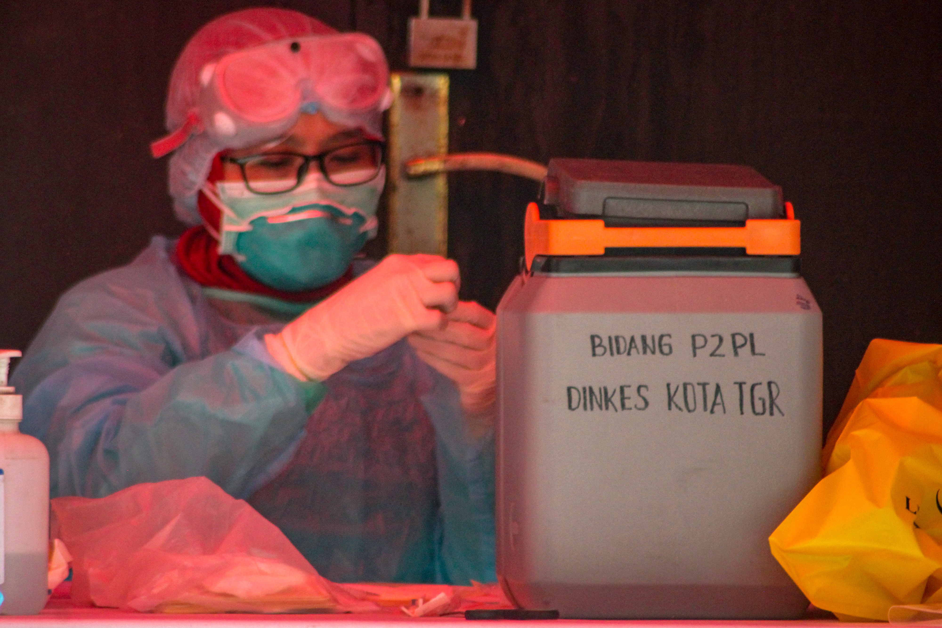 Petugas mengamati sampel swab spesimen saat swab test di LABKESDA Kota Tangerang, Banten (2/4)