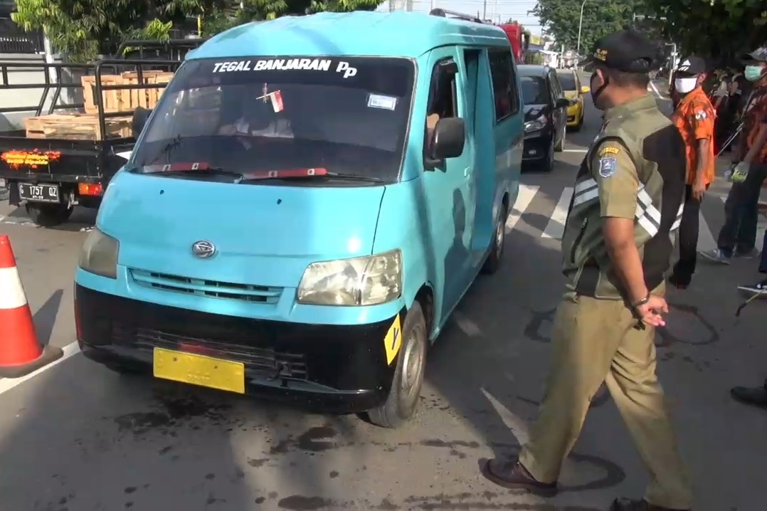 Petugas Satpol PP Kota Tegal, Jawa Tengah, menegur sopir angkut menaikkan penumpang sebelahnya, Sabtu (25/4).