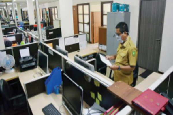 Seorang ASN Pemprov Riau saat mendapat giliran masuk bekerja di Dinas Komunikasi Informatika dan Statistik Riau, Kota Pekanbaru, kemarin.