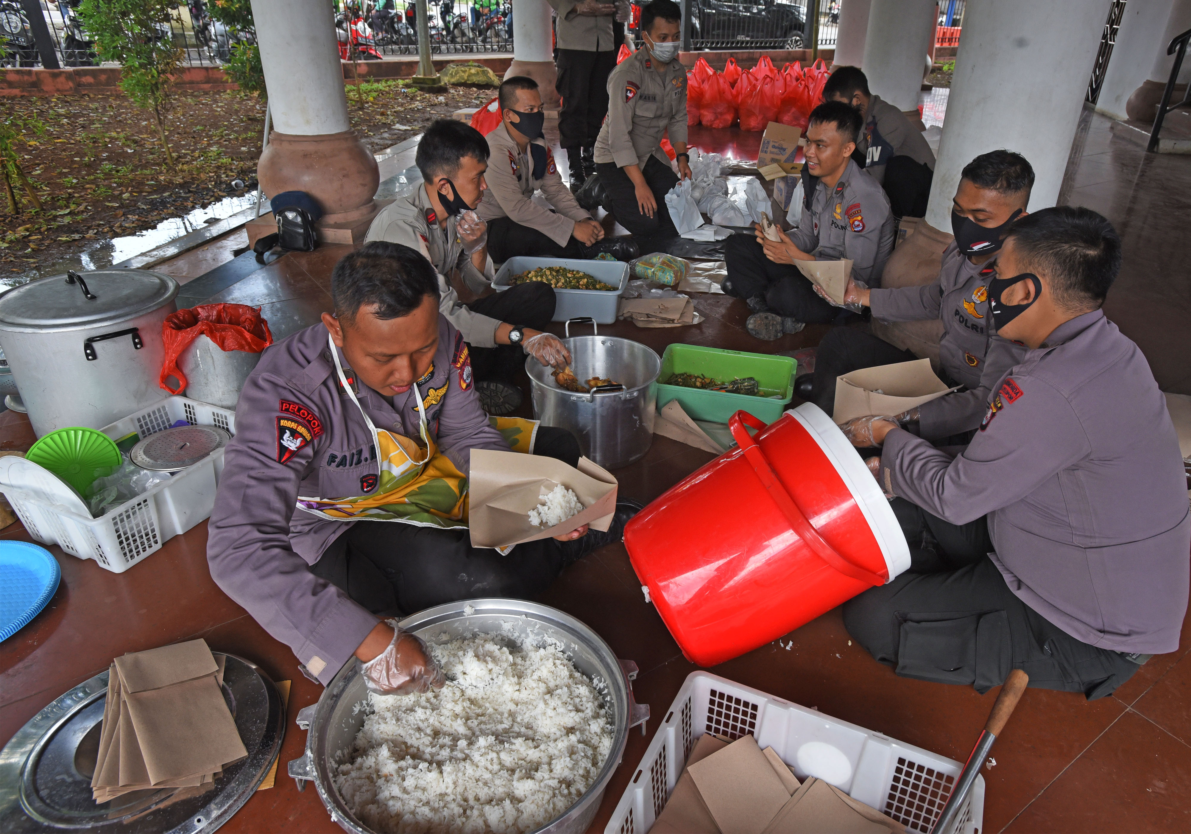 Sejumlah personel Polda Banten membungkus nasi dan sayur mayur saat membuka dapur umum di Alun-alun Serang, (14/4)