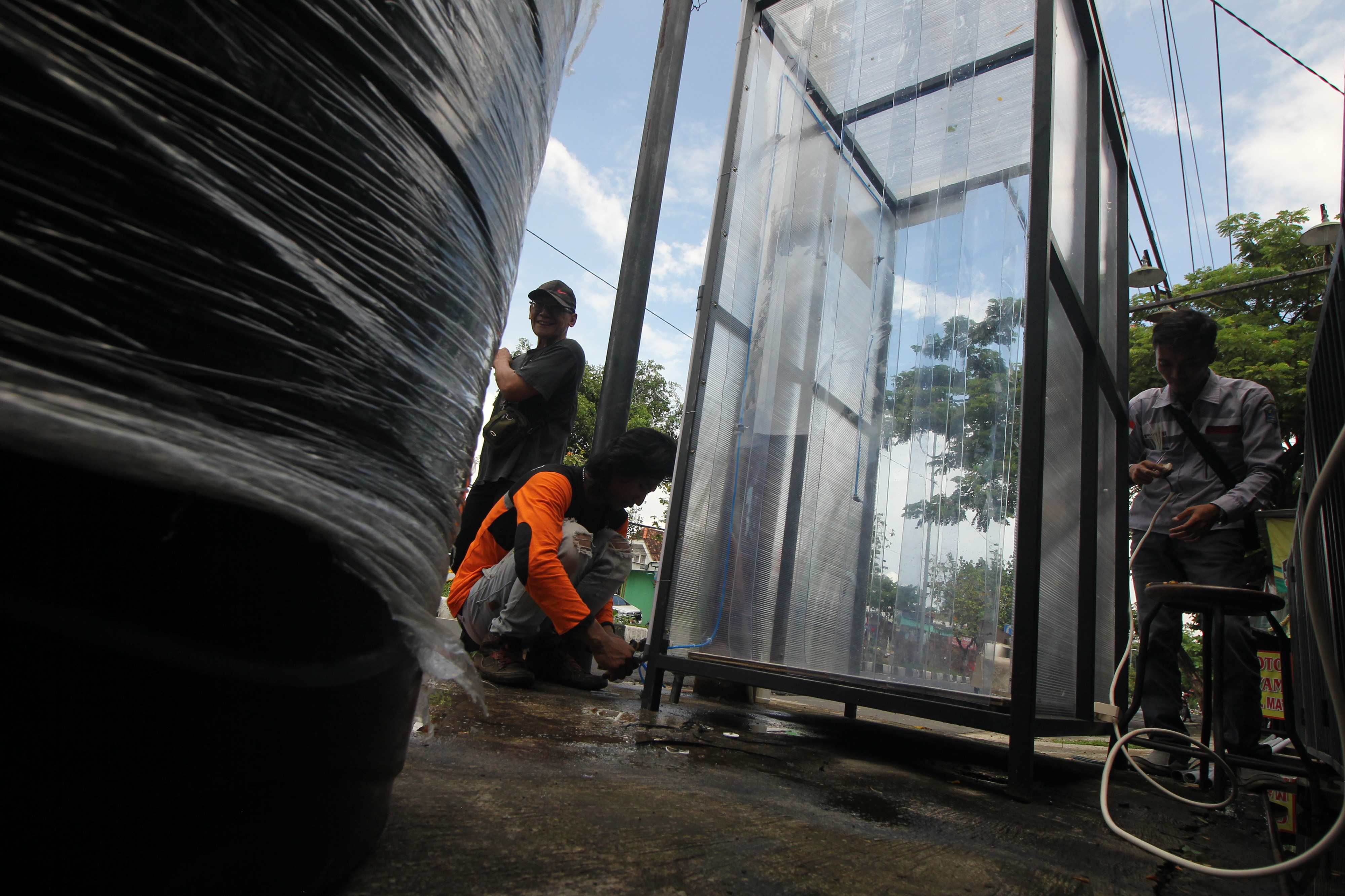 Petugas memasang bilik disinfektan di pinggir jalan di kawasan Pacar Keling, Surabaya, Jawa Timur, Kamis (2/4). 