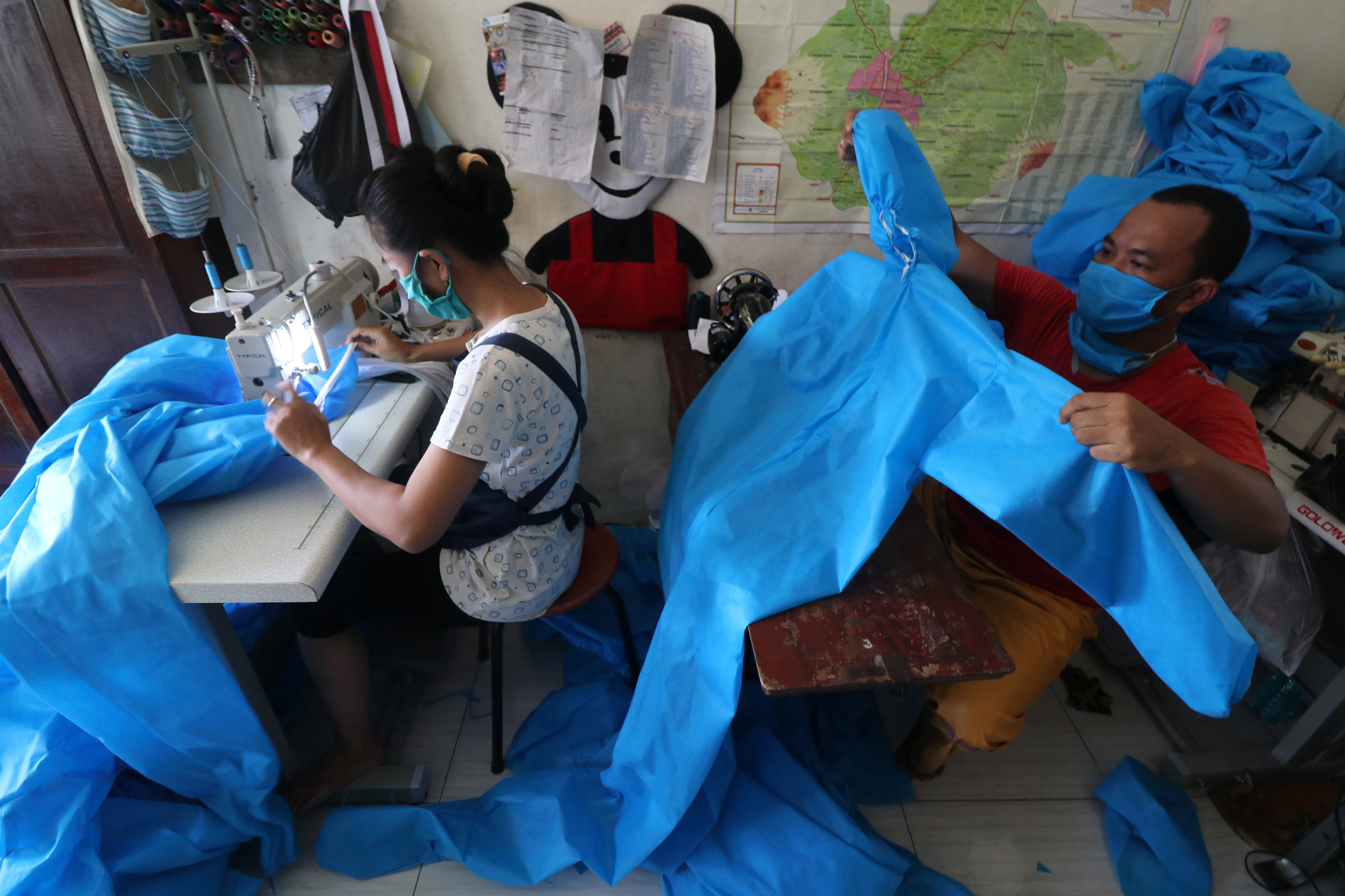 Ilustrasi--Penjahit menyelesaikan pembuatan pakaian Alat Pelindung Diri (APD) di Kelurahan Campurejo, Kota Kediri, Jawa Timur.