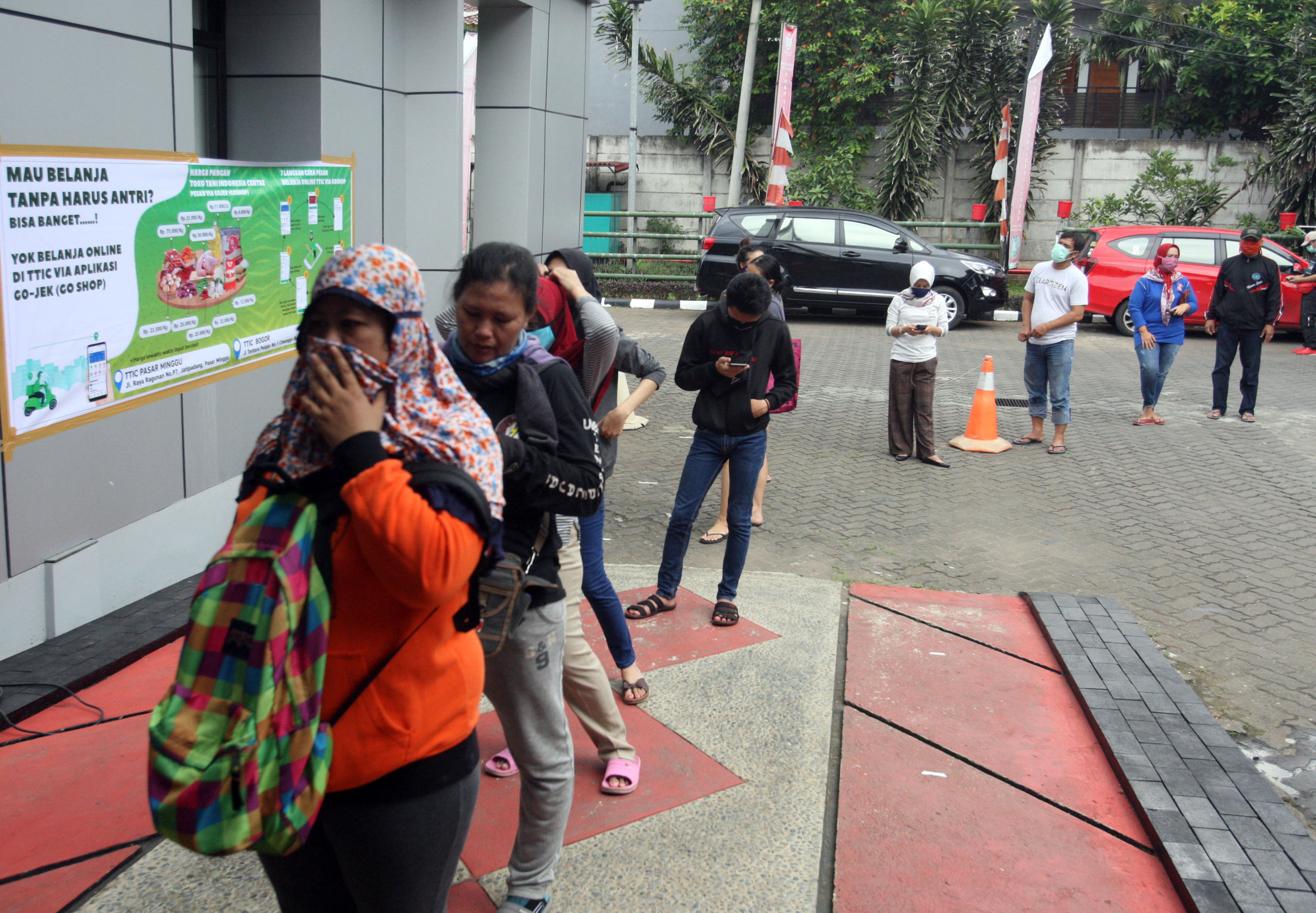 Warga dan pengemudi ojek daring antre membeli bahan makanan di Toko Tani Indonesia Center (TTIC) Pasar Minggu, di Jakarta, Sabtu (4/4).