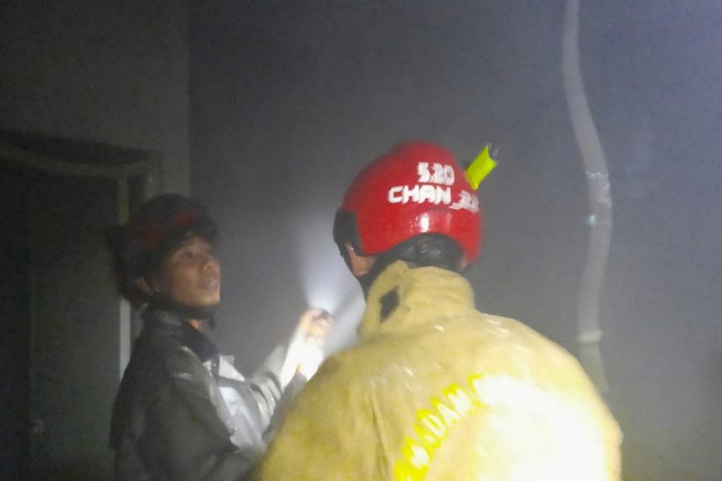 Petugas pemadam kebakaran mengecek sisa api pada ruangan di lantai dua gudang penyimpanan makanan yang terbakar.