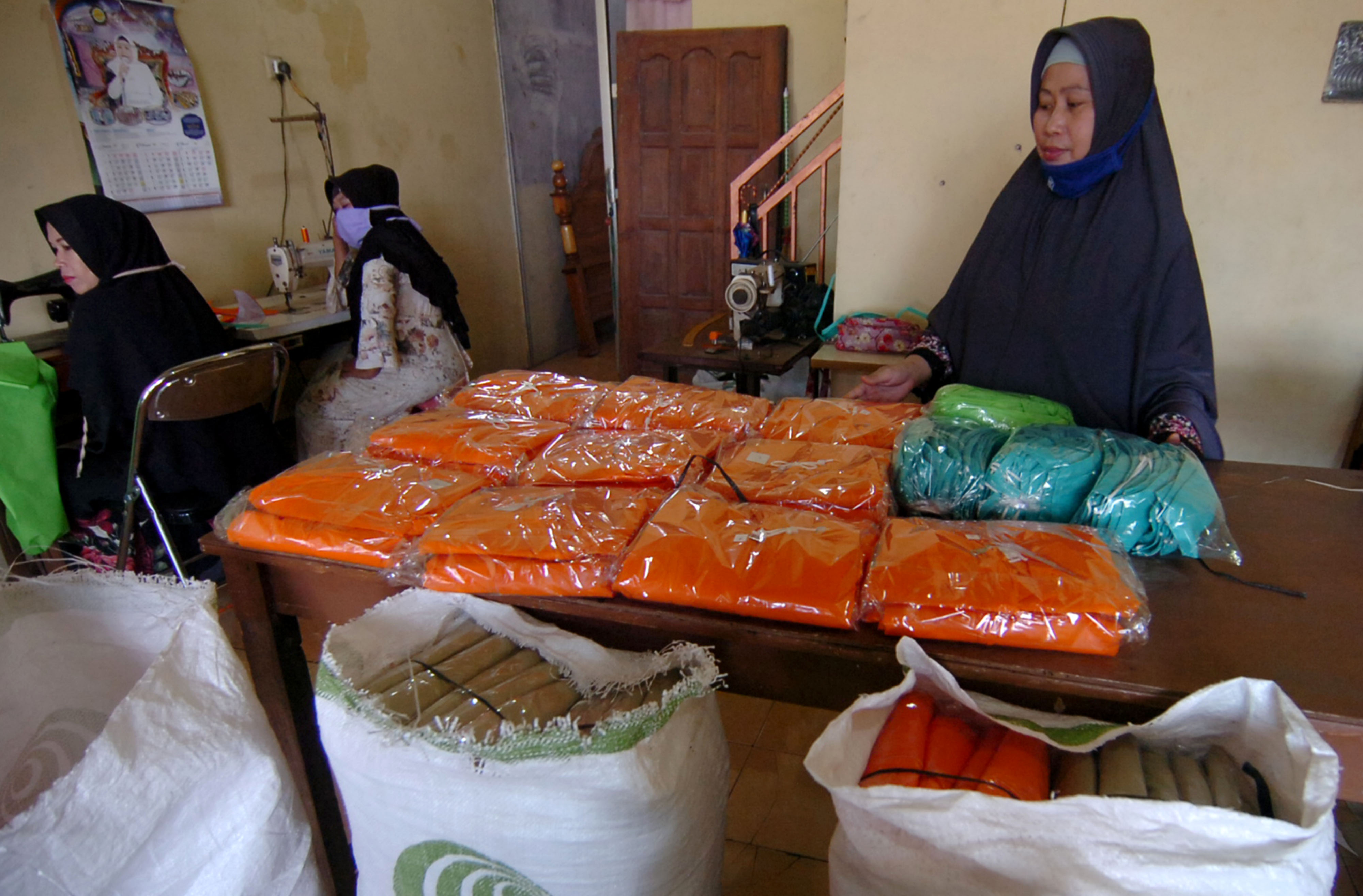 Pekerja menata APD berbahan polypropylene di industri penjahit rumahan Kelurahan Pesurungan, Tegal, Jawa Tengah, Sabtu (11/4).