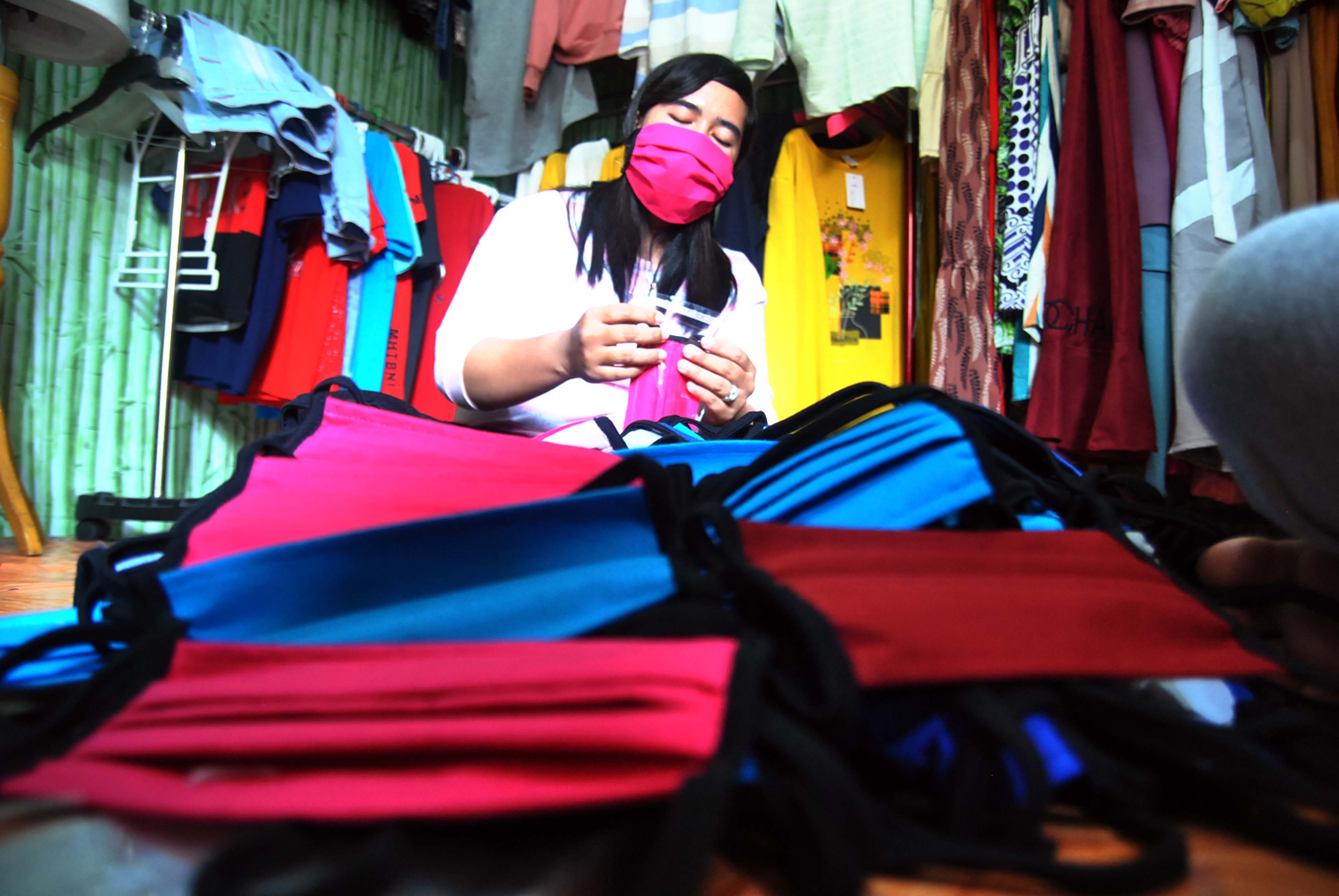 ekerja menyelesaikan pembuatan masker dari bahan kain katun combed di Kaos Bogor 767 Teguh Printing, Sindang Barang Pilar, Bogor.