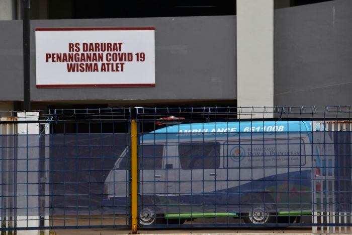 Petugas mengendarai ambulans berisi pasien memasuki Rumah Sakit Darurat Penanganan COVID-19 di Wisma Atlet Kemayoran, Jakarta.