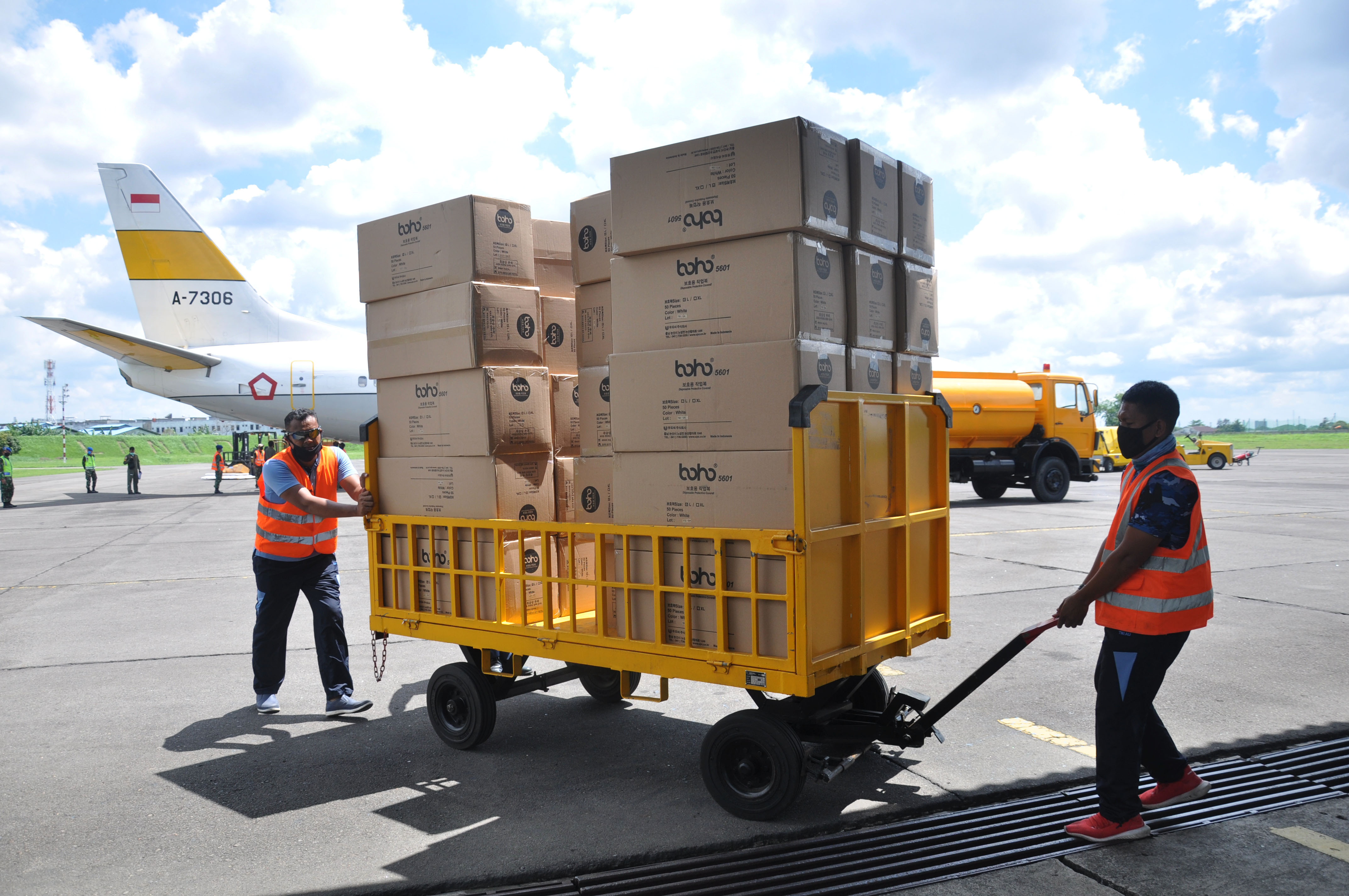 jurit TNI AU membongkar muat sejumlah kotak kardus berisi Alat Pelindung Diri (APD) dari pesawat saat tiba di Lanud Soewondo Polonia, Medan