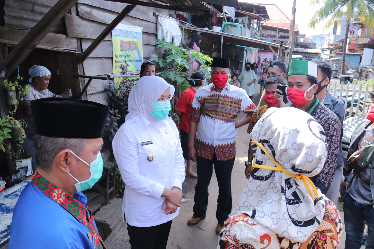 Wakil Wali Kota Palembang Fitrianti Agustinda berbincang dengan warga saat memberikan bantuan di Kelurahan 24 Ilir, Jumat (17/4). 