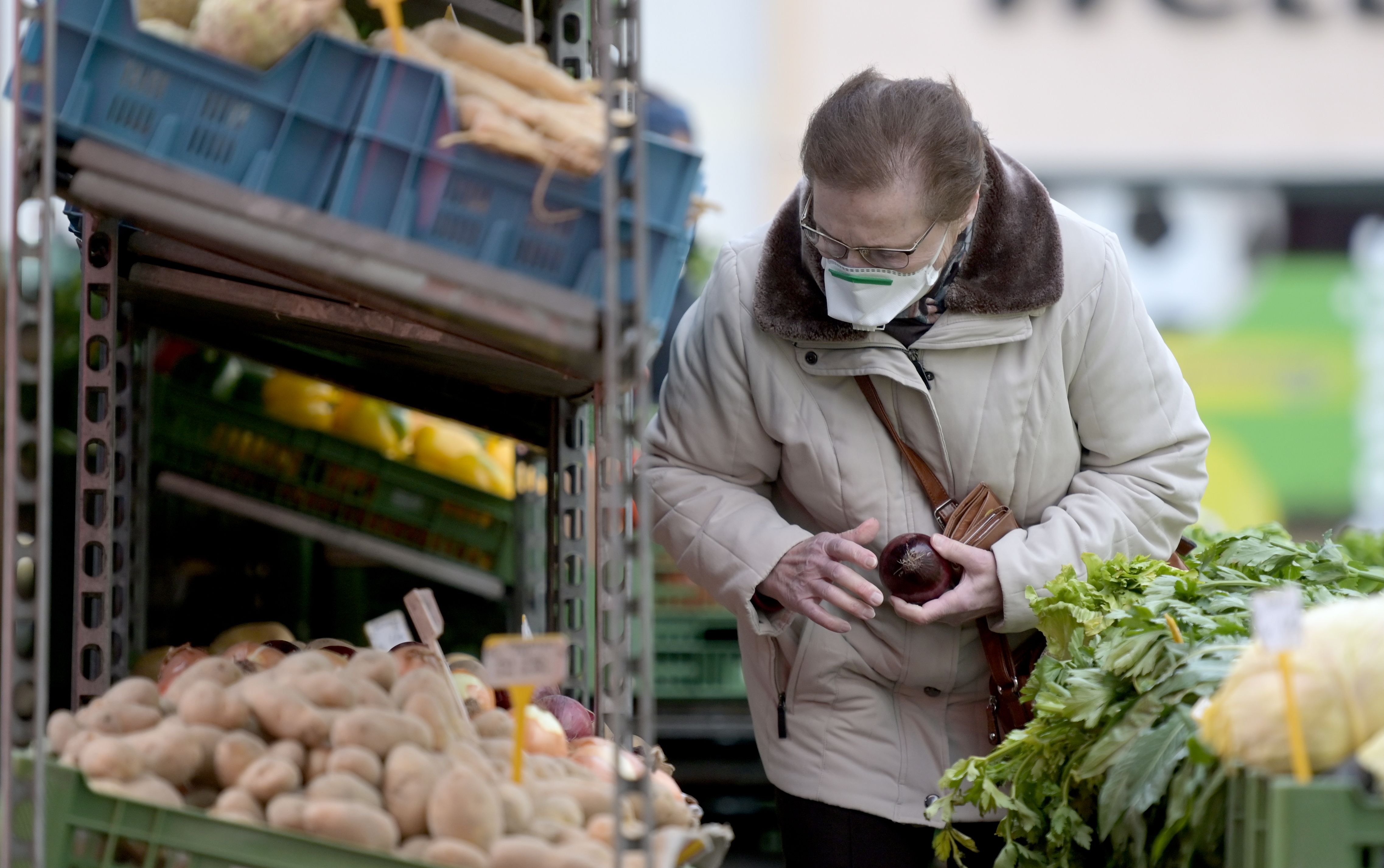 Seorang perempuan mengenakan masker berbelanja sayuran di Meidlinger Markt, Wina, Austria.