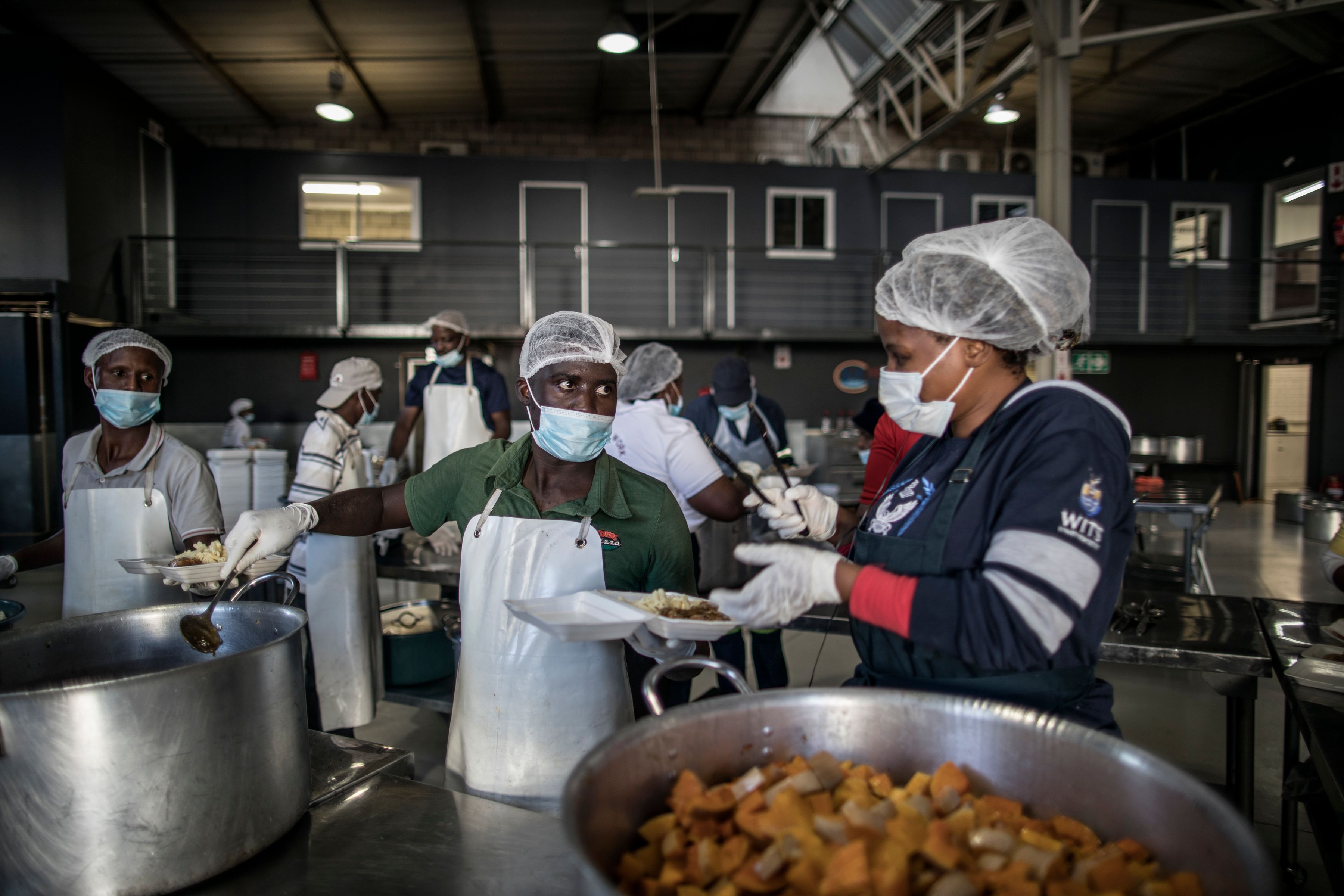 Relawan membagikan makanan kepada tuna wisma di Johannesburg, Afrika Selatan, selama masa lockdown.