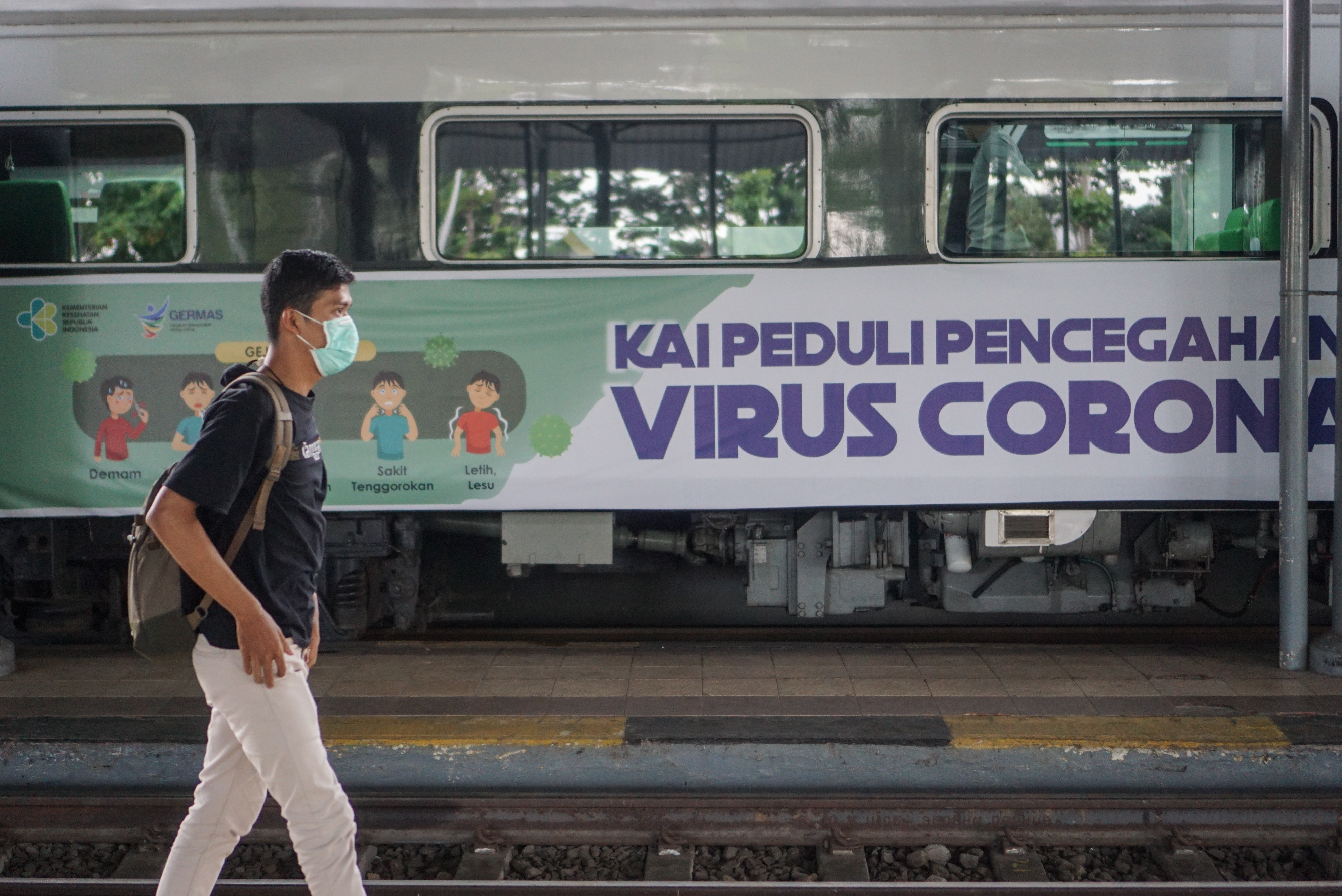  Calon penumpang melintas di dekat kereta real clinic di Stasiun Balapan, Solo, Jawa Tengah, Jumat (6/3/2020). 