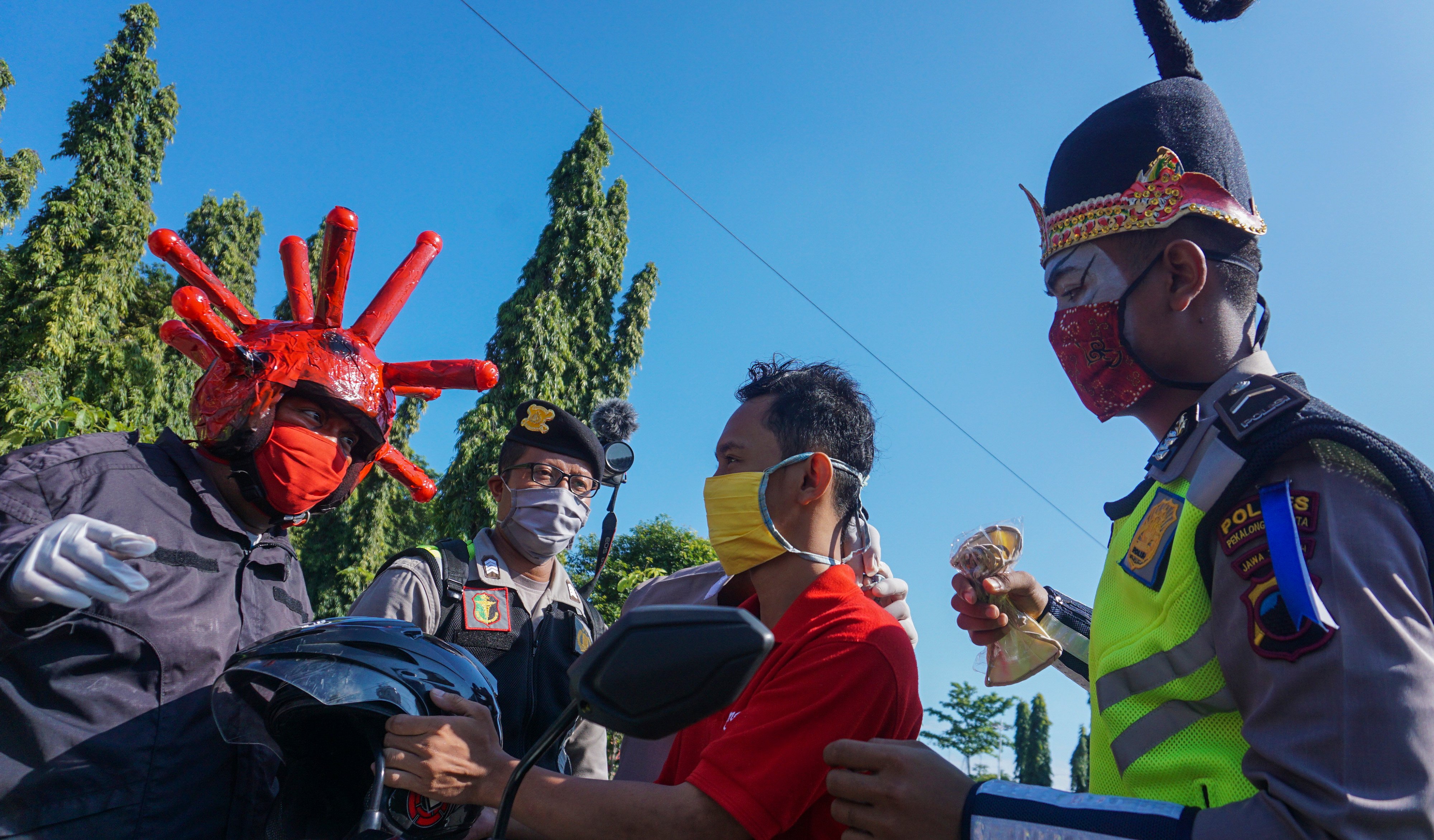 Petugas Satlantas Polres Pekalongan Kota menggunakan kostum punokawan membagi masker kepada pengguna jalan, Selasa (14/4).